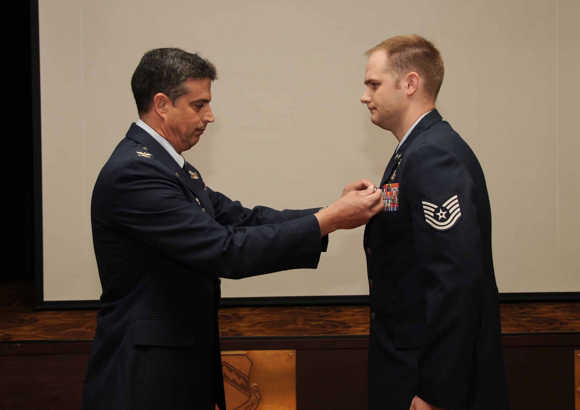 Col. Jose Monteagudo, 944th Fighter Wing commander, presents a Bronze Star Medal to Tech. Sgt. Steven Hager, 944th Civil Engineer Squadron Explosive Ordnance Disposal Flight, during commander’s call March 5, 2011. While deployed to Afghanistan, Sergeant Hager performed 93 counter-improvised explosive device missions. On one of the missions, Sergeant Hager responded to an Army vehicle that had been involved in an improvised explosive device denotation. Sergeant Hager assisted the medic  with extracting three seriously wounded Soldiers from the vehicle while his team helped with two additional personnel injured by the blast. After the Soldiers were prepared for medical evacuation, Sergeant Hager rendered safe the IED near the vehicle and completed the mission. His actions led to the identification of new enemy IED cell tactics leading to the safety of future patrol missions. During another mission, Sergeant Hager was engaged in an enemy ambush. Despite being fired upon with Rocket Propelled Grenades, Sergeant Hager continued his sweep for IEDs and was able to locate the termination point. His brave actions enabled him to collect vital evidence for further analysis that determined the IED was actually a hoax scenario intended to lure his patrol team into the area. Authorized Feb. 4, 1944, the Bronze Star Medal is awarded to members of all branches of military service for combat heroism or meritorious service. (U.S. Air Force photo/Staff Sgt. Denise Willhite)
