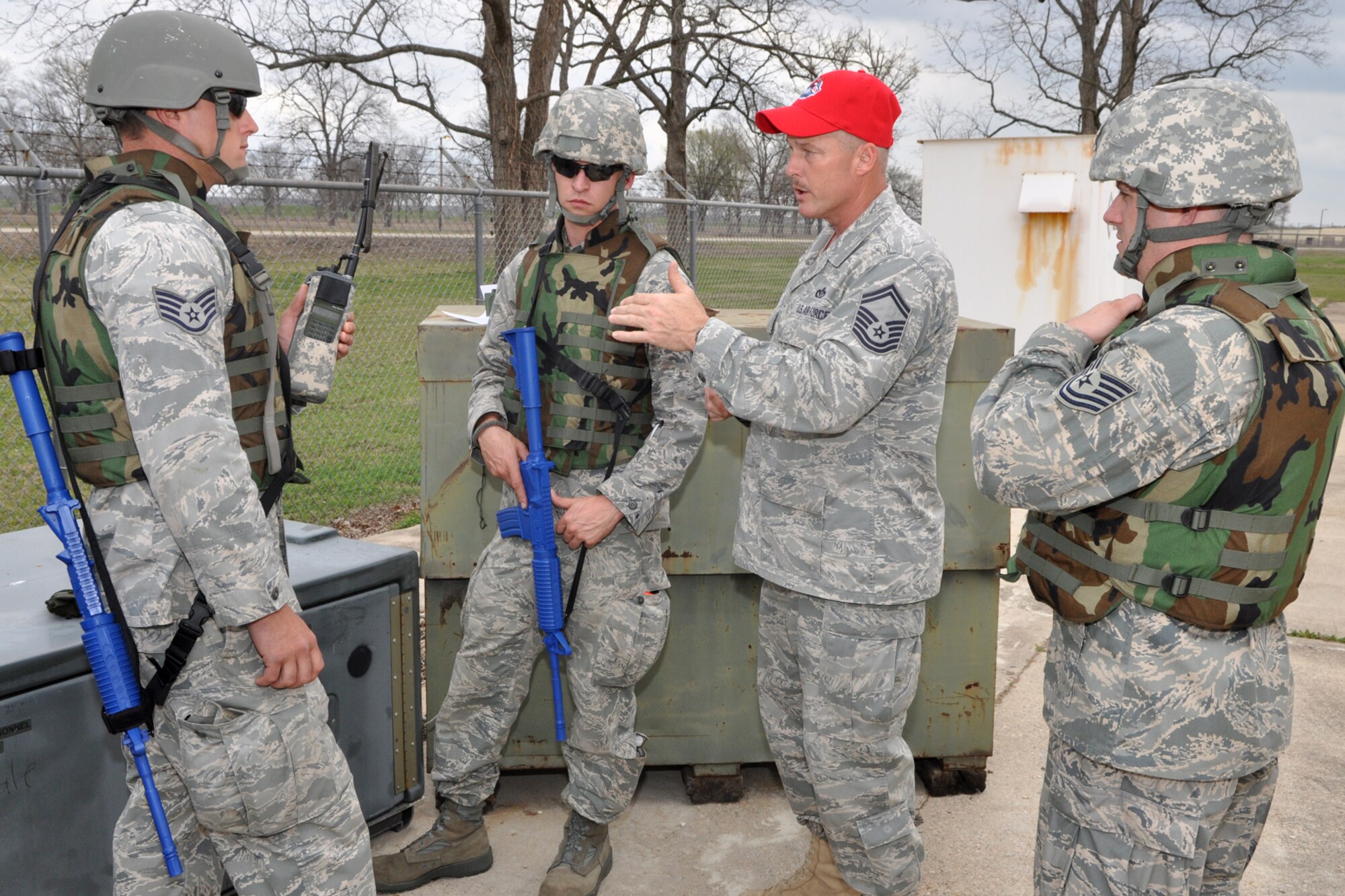 (L-R) Staff Sgt. Tyler Whisenhunt, structural Journeyman, Staff Sgt. Michael Sullivan, structural Journeyman, Senior Master Sgt. Rodney Kilby, cantonments chief, and Technical Sgt. Brent Streiff, security forces trainer, discuss perimeter security during a four-day exercise at the RED HORSE Squadron compound on Barksdale Air Force Base, La., March 4, 2011. All four Airmen are assigned to the 307th RED HORSE Squadron at Barksdale and are participating in an exercise that is simulating a deployment to a Southwest Asia location where the Airmen are building helicopter landing pads for a U.S. Marine Unit. (U.S. Air Force photo/Tech. Sgt. Jeff Walston)
  

