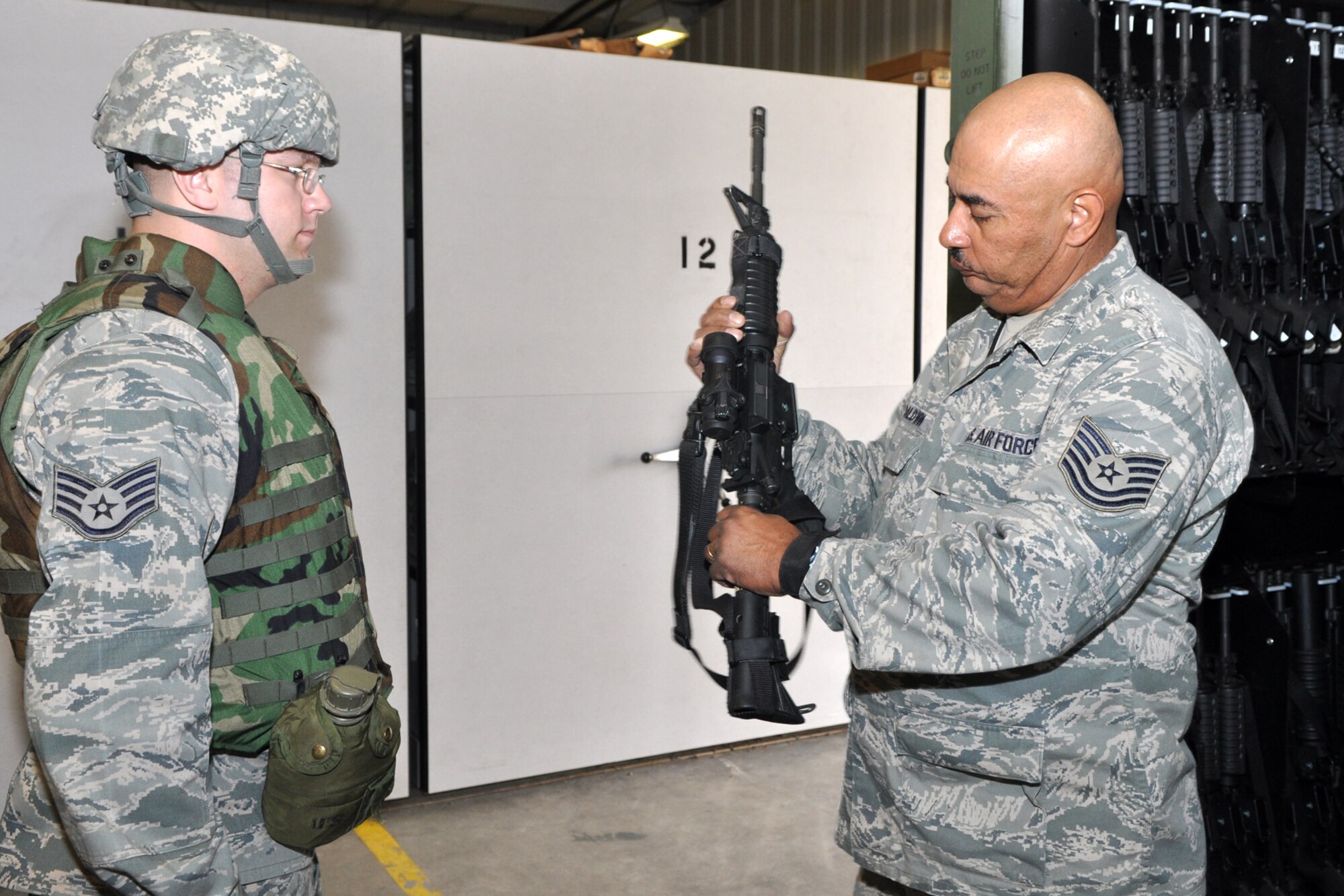 Technical Sgt. Michael Baldwin, who is a pavement and concrete heavy equipment operator, checks a weapon turned in by Staff Sgt. Wayne Shipman, structural journeyman, before stowing it in a weapons locker at the RED HORSE Squadron compound at Barksdale Air Force Base, La., March 4, 2011. Both Airmen are assigned to the 307th RED HORSE Squadron and are participating in the four-day exercise, simulating a deployment to a Southwest Asia location where the Airmen would be building helicopter landing pads for a U.S. Marine Unit. (U.S. Air Force photo/Tech. Sgt. Jeff Walston)