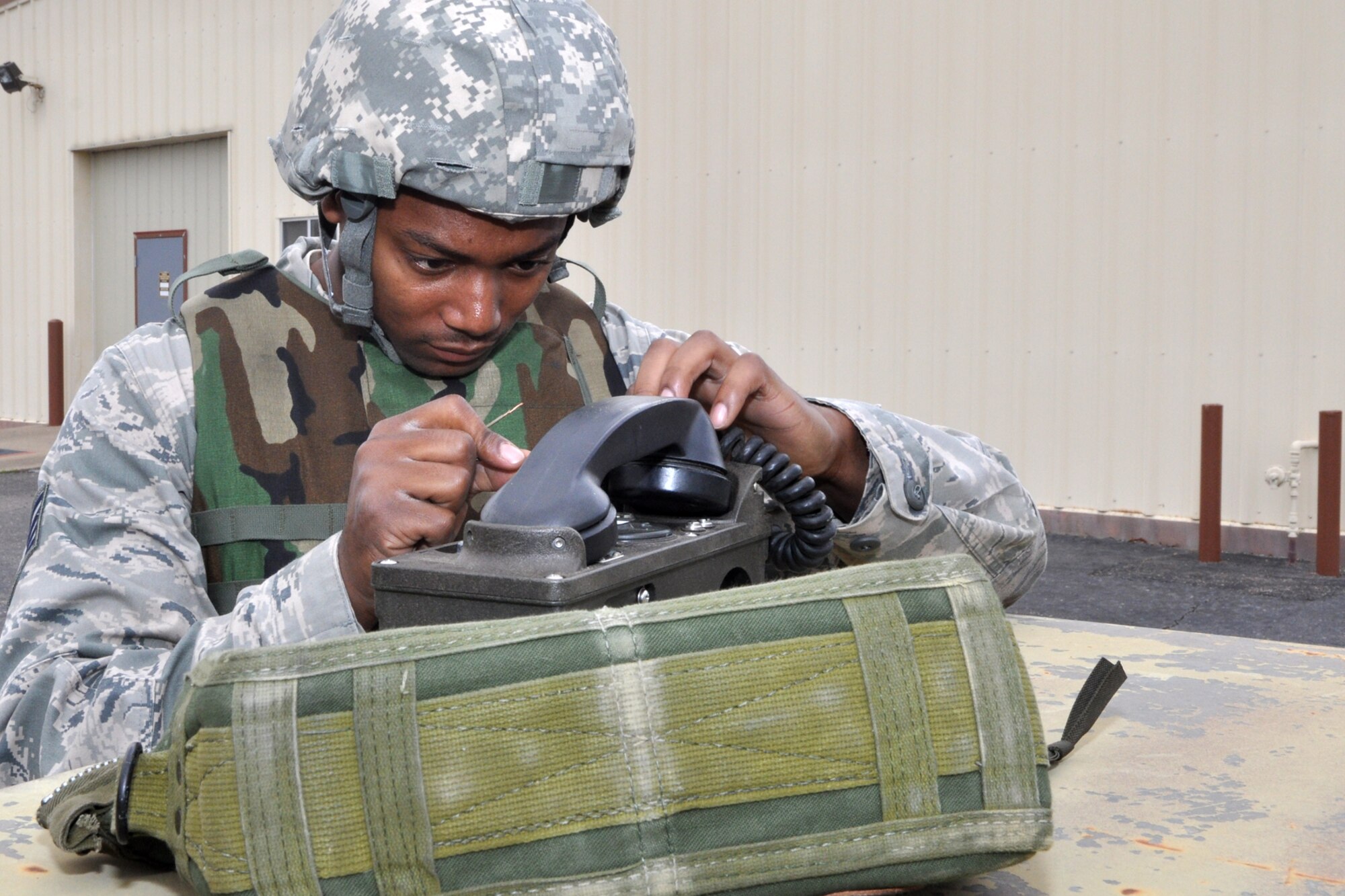 Staff Sgt. Tyler Yarbrough, a heavy equipment operator assigned to the 307th RED HORSE Squadron, attaches communication wires to his phone during an exercise at Barksdale Air Force Base, La., March 4, 2011. Sergeant Yarbrough is participating in a four-day exercise, designed to simulate a deployment to a Southwest Asia location where the unit would build helicopter landing pads for a U.S. Marine Unit. (U.S. Air Force photo/Tech. Sgt. Jeff Walston)