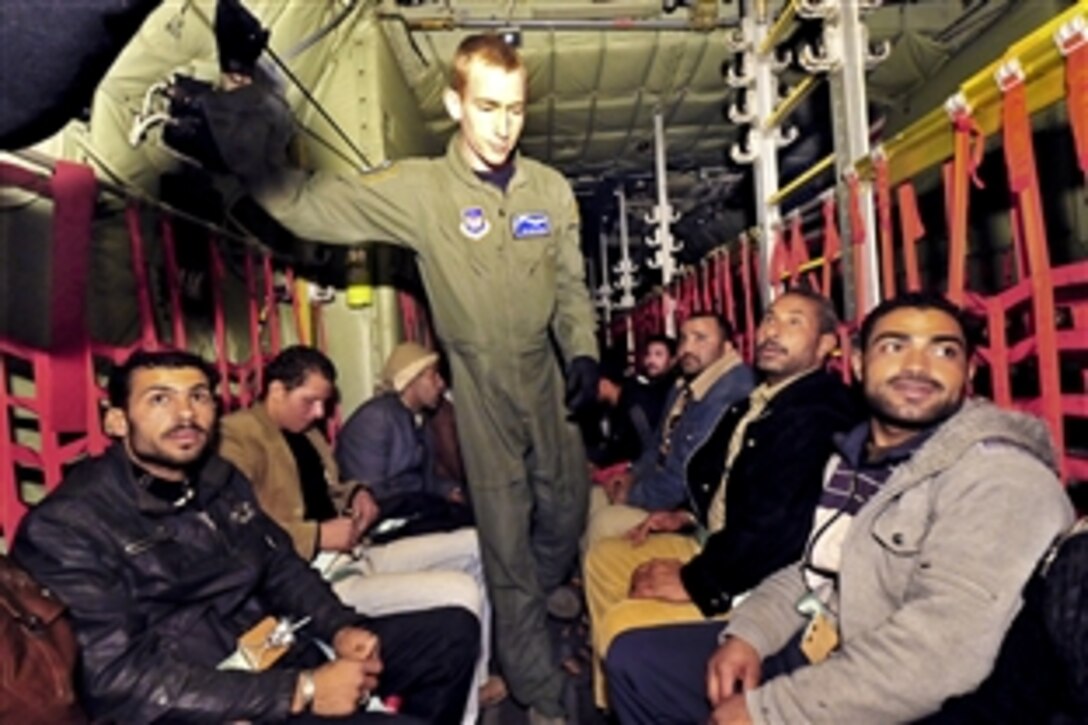 A U.S. Air Force airman stands among displaced Egyptian citizens aboard a U.S. Air Force C-130 aircraft, March 5, 2011. The passengers boarded the aircraft in Djerba, Tunisia, after fleeing recent violence and political instability and are being transported to Cairo, Egypt. U.S. military aircraft began airlifting evacuees as part of a broader government effort to provide humanitarian aid during the crisis the in Libya. 