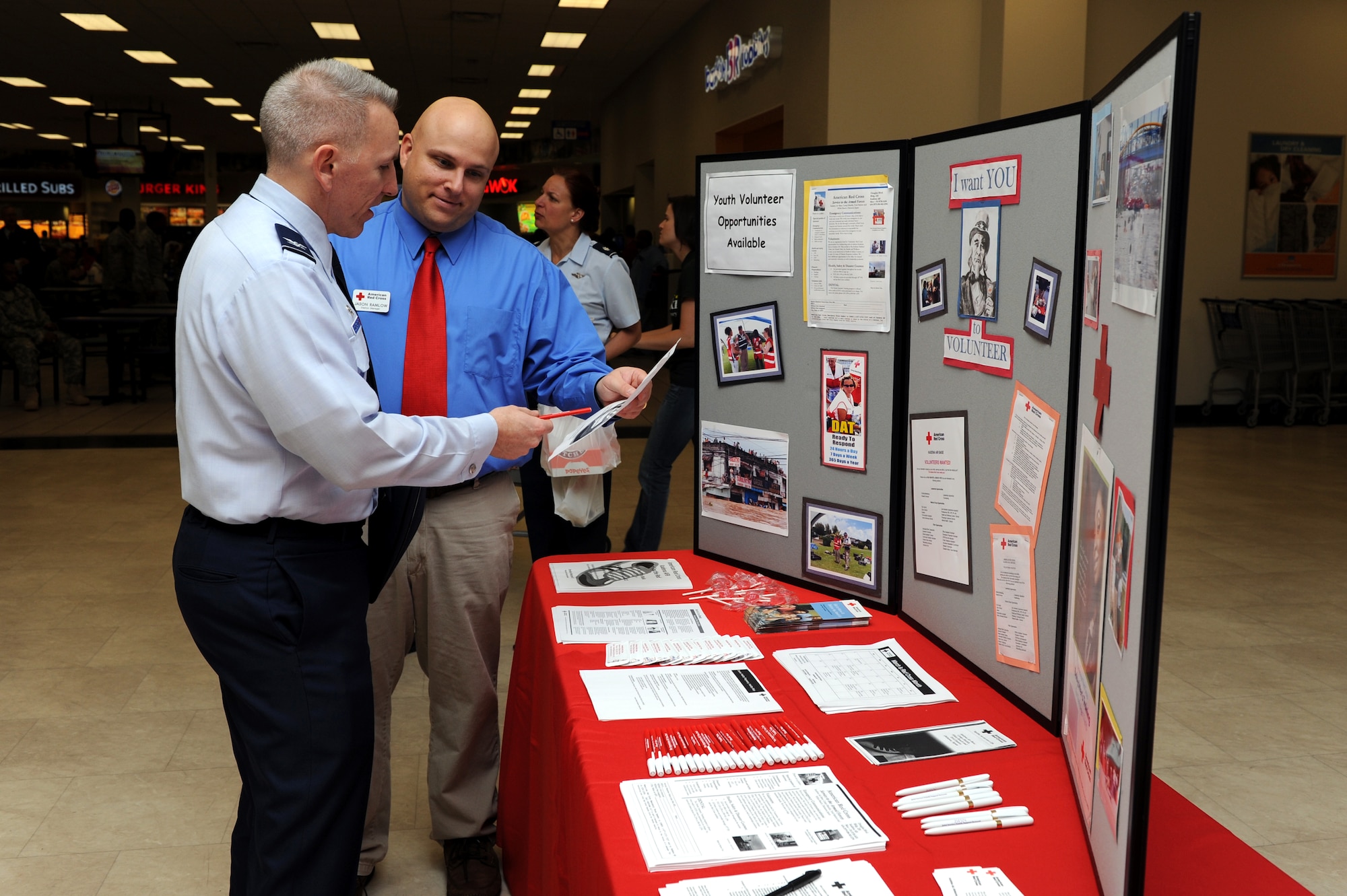 Col. Roftiel Constantine,18th Mission Support Group commander, and Mr. Jason Ramlow, station manager from the American Red Cross, discuss volunteer options at the Red Cross celebration at the Kadena Base Exchange, March 7. In 2010 the American Red Cross volunteers dedicated more than 16,200 hours of service to the Kadena community. (U.S. Air Force photo/Junko Kinjo)