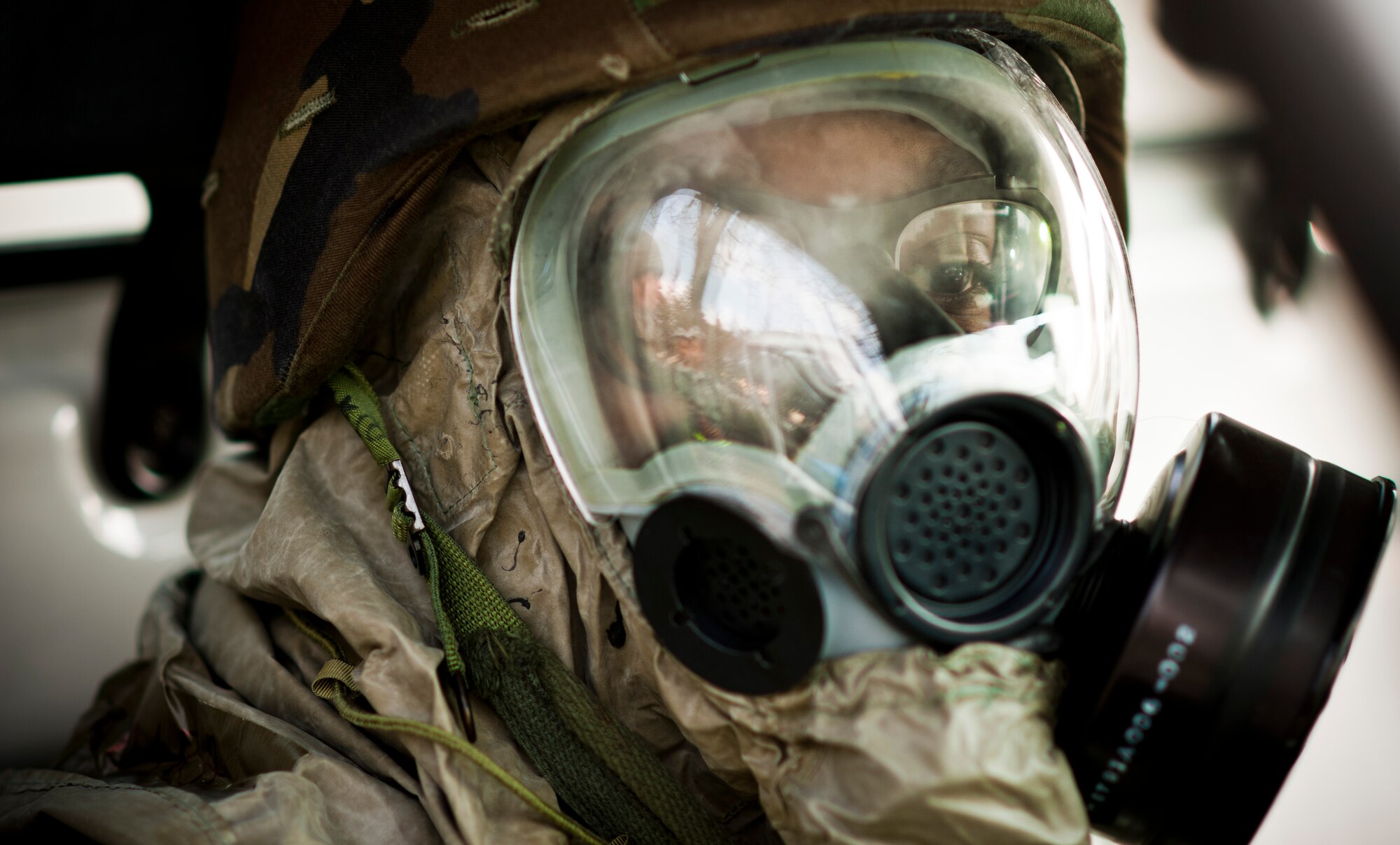 YOKOTA AIR BASE, Japan -- Airman 1st Class Damaria Burch, 374th Medical Surgical Squadron surgical technician, dons her mission-oriented protective posture gear prior to training on how to drive while in MOPP 4 during an operational readiness exercise here March 8. The edges of the MCU-2 A/P protective mask can create blind spots and tunnel vision, making driving a challenge. The MOPP 4 driving course helps Airmen learn to overcome these challenges to drive safely in MOPP 4. (U.S. Air Force photo/Staff Sgt. Samuel Morse)