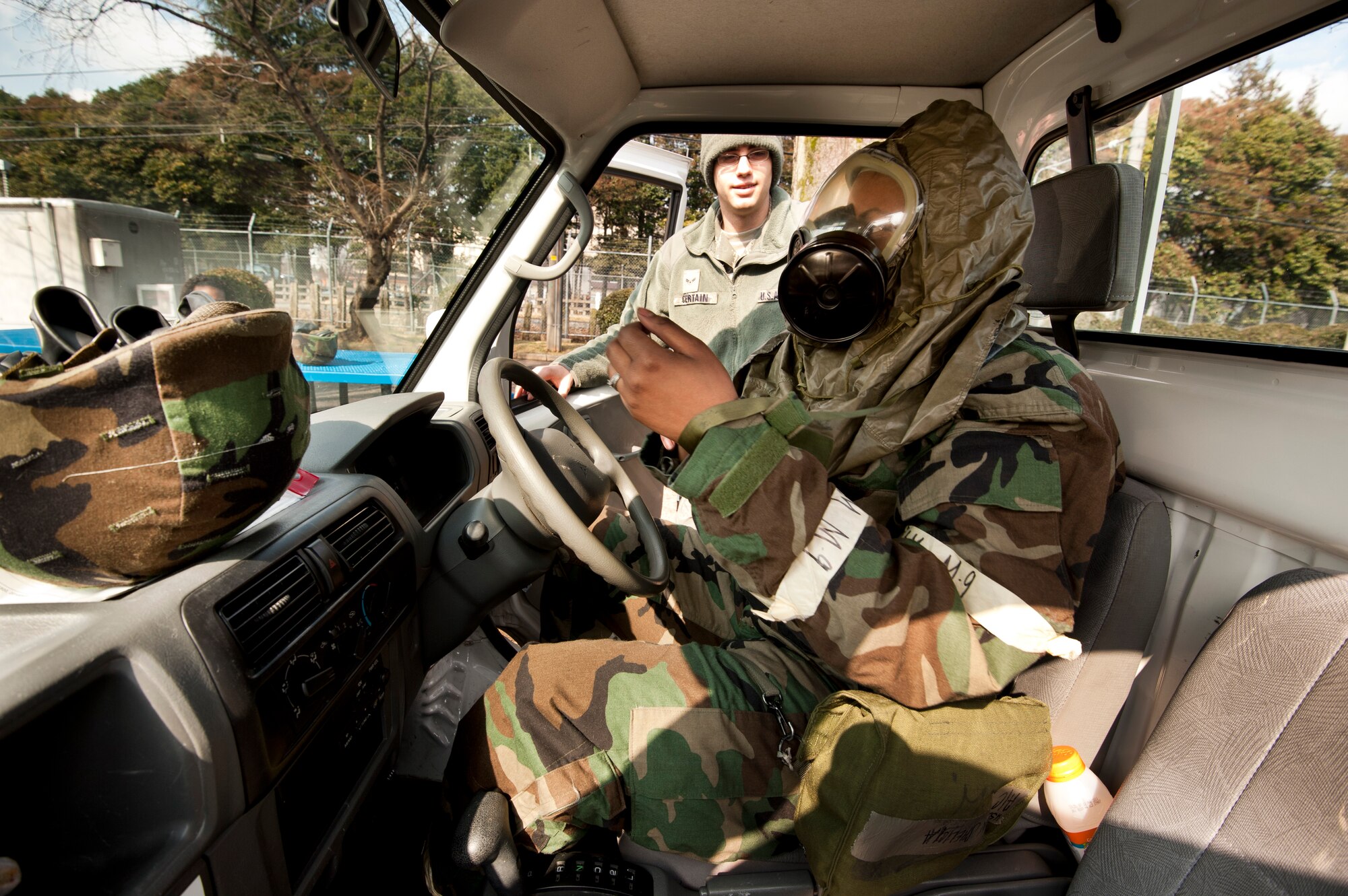 YOKOTA AIR BASE, Japan -- Airman 1st Class Shelicia Floyd, 374th Medical Support Squadron in-patient records technician, dons her mission-oriented protective posture gear prior to training on how to drive while in MOPP 4 during an operational readiness exercise here, March 8. Airman 1st Class Zachary Certain, 374th Civil Engineer Squadron emergency management MOPP 4 driving instructor, taught the class which helps Airmen become accustomed to the limitations and challenges of driving in MOPP 4 before having to do it in a real-life contingency. (U.S. Air Force photo/Staff Sgt. Samuel Morse)