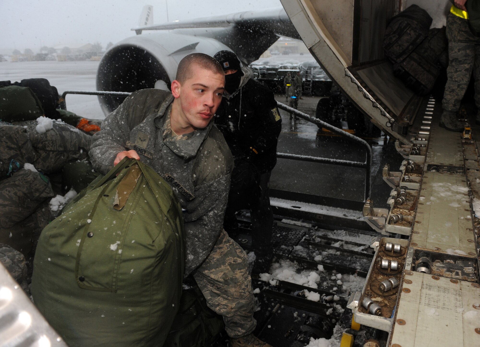 MOUNTAIN HOME AIR FORCE BASE, Idaho -- Airman 1st Class Brian Bigney, 366th Aerospace Medical Squadron bioenvironmental engineer, loads the 389th Aircraft Maintenance Unit's baggage onto an aircraft before a deployment, March 7. More than 400 Airmen from across the 366th Fighter Wing are deploying in support of Operation Enduring Freedom. Airmen in a variety of non-aviation roles are scheduled to conduct a wide range of tasks to ensure the success of providing critical combat power capabilities. (U.S. Air Force photo by Senior Airman Debbie Lockhart)
