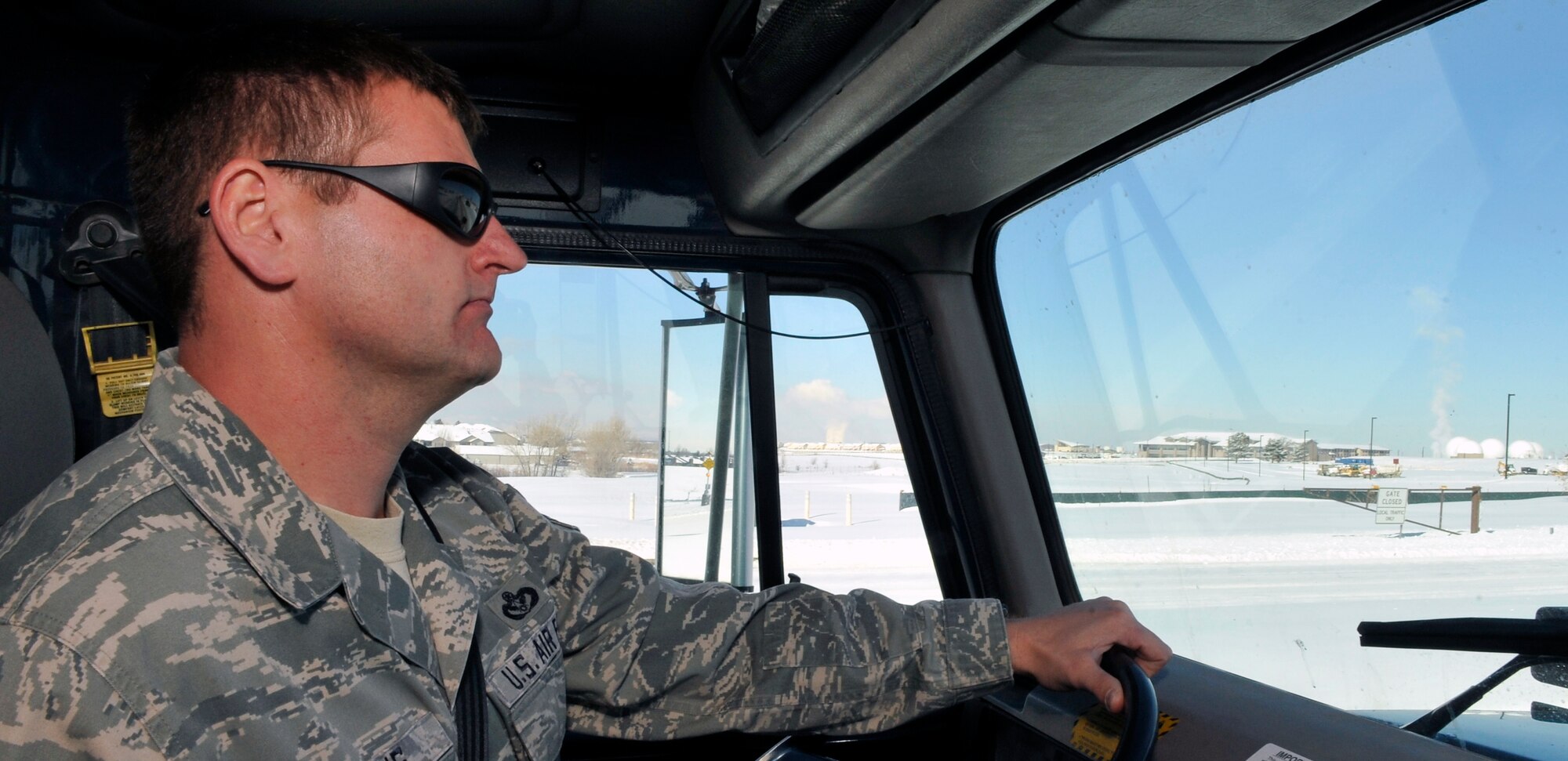 BUCKLEY AIR FORCE BASE, Colo. --MSgt Bobby Wilkins, 460th Civil Engineering Squadron, drives a snow plow on Buckley AFB January 10. From plumbers to structures everyone in Civil Engineering pulls together to complete the job.  (U.S. Air Force photo by Airman 1st Class Paul Labbe.)
