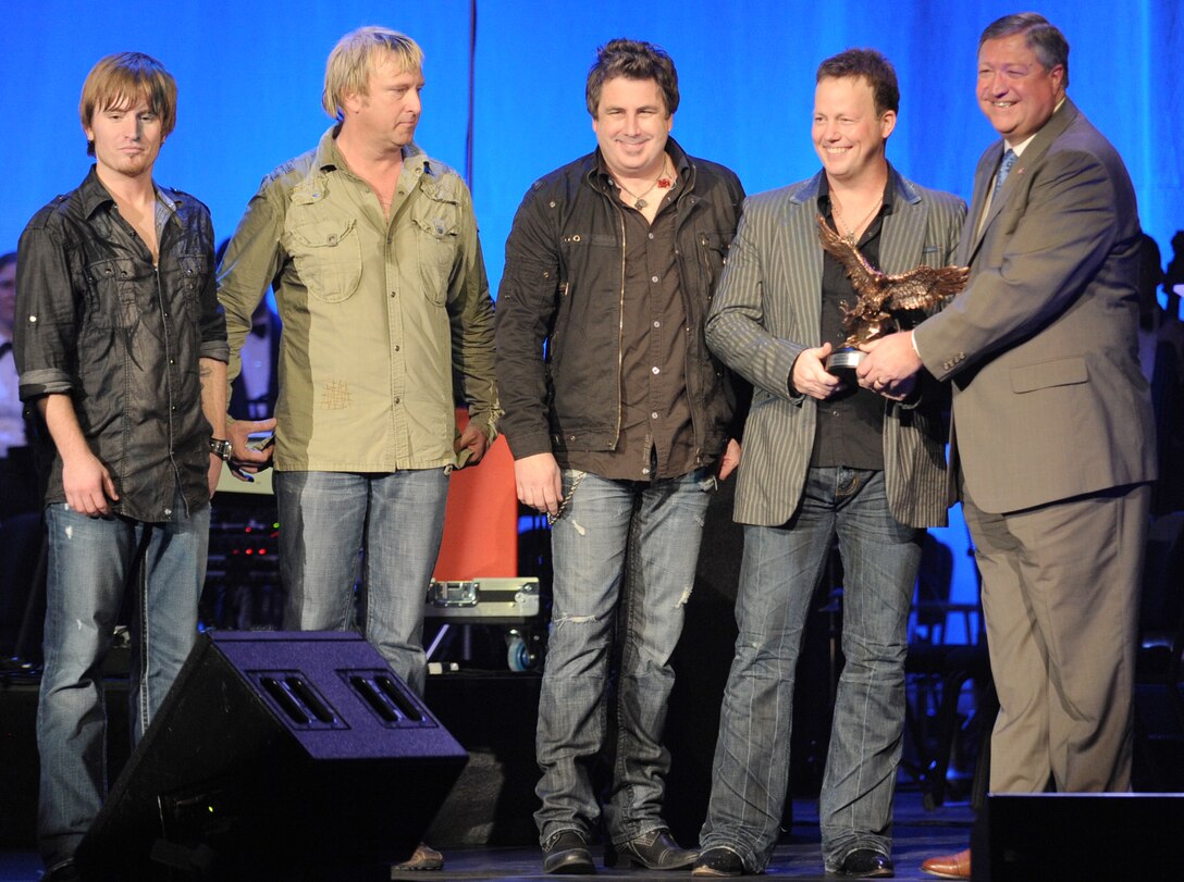 Country music group Lonestar receives an eagle statue from Secretary of the Air Force Michael B. Donley at the Daughters of the American Revolution Constitution Hall, Washington D.C., March 6. Lonestar performed with The U.S. Air Force Band to close out the USAF Band's 2011 Guest Artist Series. 