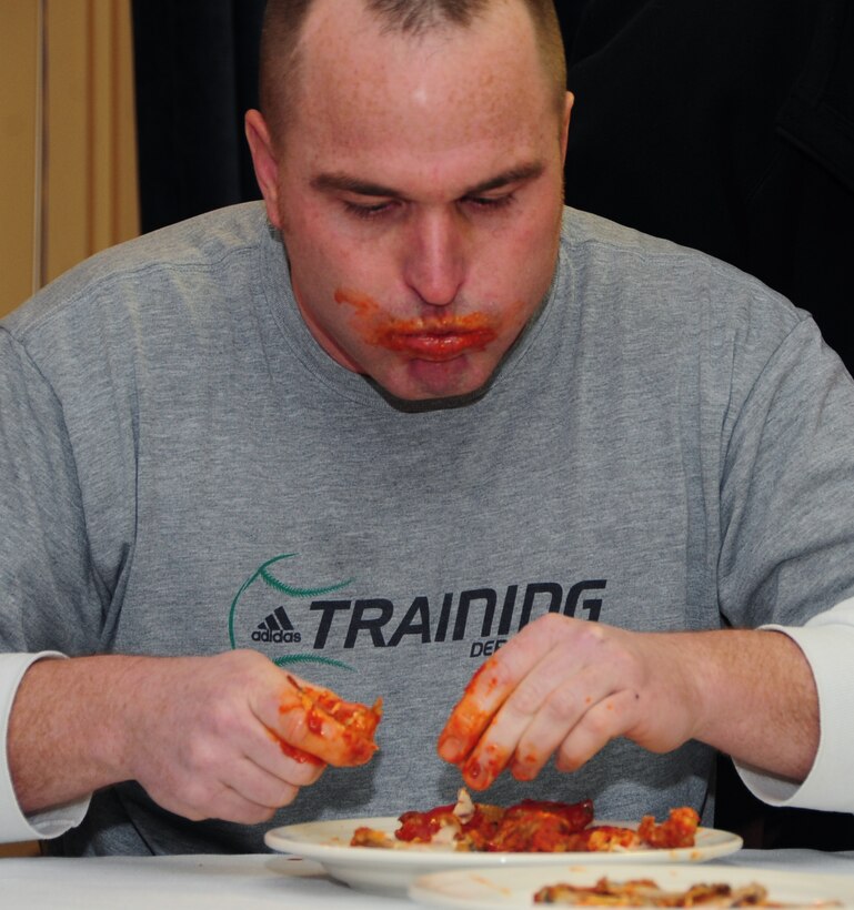 Tech. Sgt. Eddie Byrns, 28th Civil Engineer Squadron electrical systems technician, chows down on hot wings during the first "Man vs. Food" competition at Ellsworth Air Force Base S.D., March 4, 2011.  Sixteen Airmen from across the base participated in the competition to see who could eat a dozen “atomic” hot wings within three minutes. (U.S. Air Force photo/Senior Airman Anthony Sanchelli)
