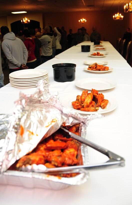 As Airmen line up for the first "Man vs. Food" competition at Ellsworth Air Force Base S.D., hot wings are ready and waiting to be devoured for the competition, March 4, 2011.  Sixteen Airmen from across the base participated in the competition to see who could eat a dozen “atomic” hot wings within three minutes. (U.S. Air Force photo/Senior Airman Anthony Sanchelli)
