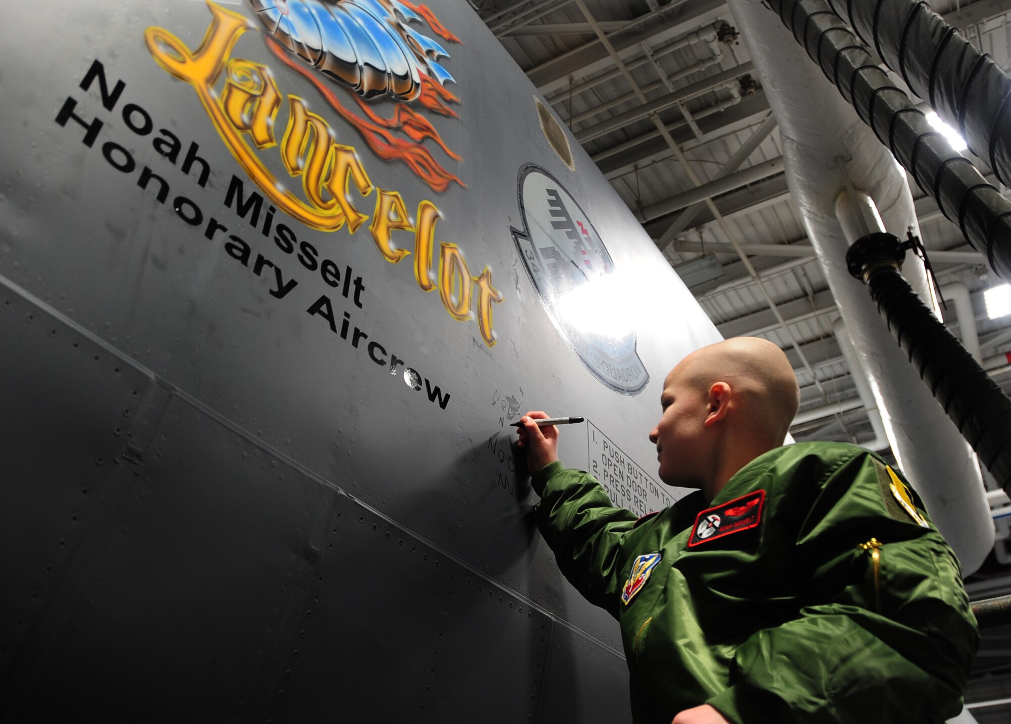 Eight-year-old Noah Misselt from Box Elder, S.D., autographs the B-1B Lancer with his name on it during the Aircrew for a Day program at Ellsworth Air Force Base, S.D., March 4, 2011.  Noah is the third youth to participate in the program since it was revised in June 2010. (U.S. Air Force photo/Senior Airman Anthony Sanchelli)  
