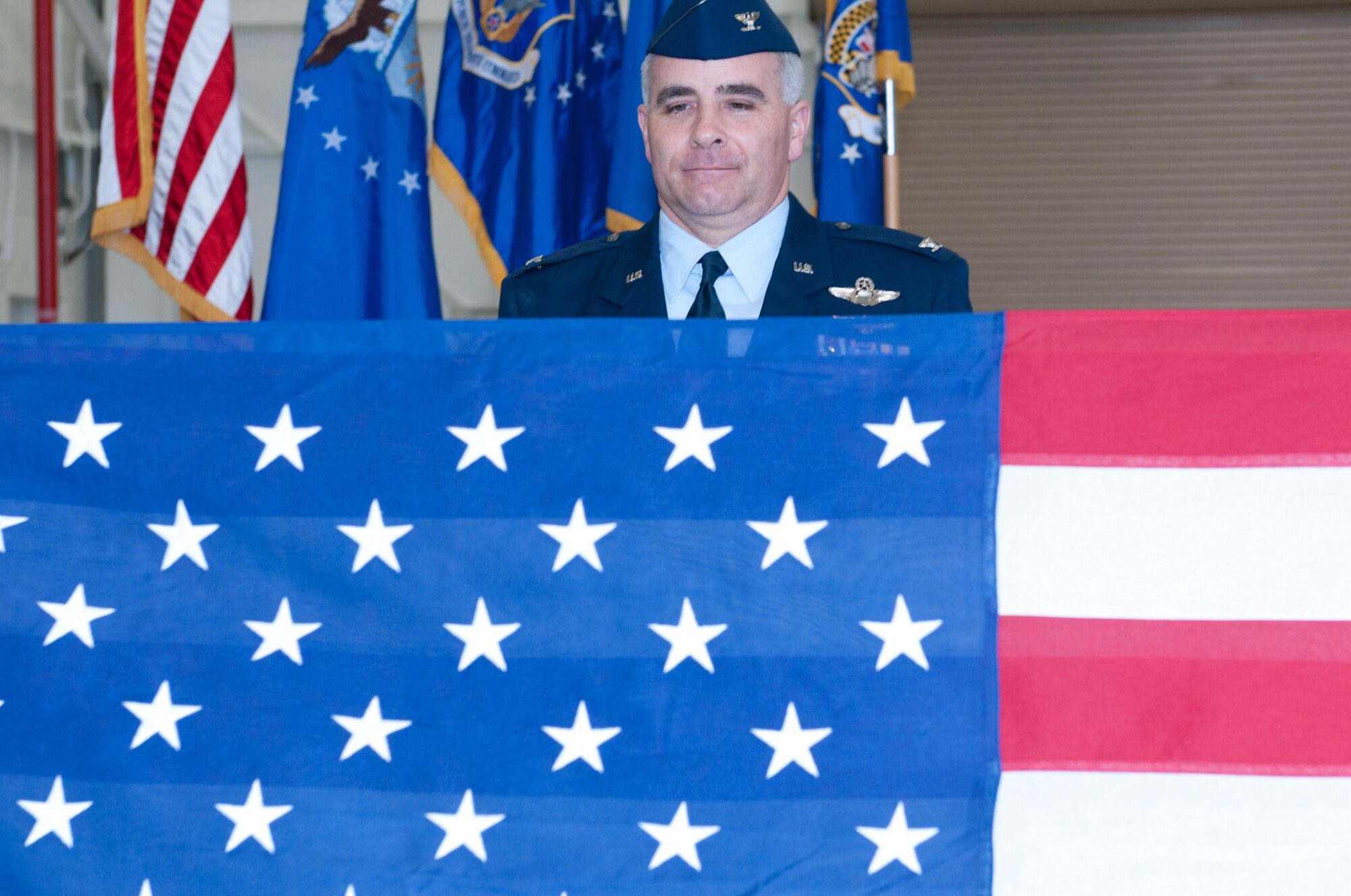 JOINT BASE ANDREWS, Md. -- Col. James M. Allman observes the folding of the U.S. flag by 69th Aerial Port Squadron honor guard during his retirement ceremony here Mar. 5. Colonel Allman, a former Naval aviator, retired after 26 years of military service, over 12 of which has been with the Air Force Reserve. (U.S. Air Force photo/Staff Sgt. Sophia Piellusch)