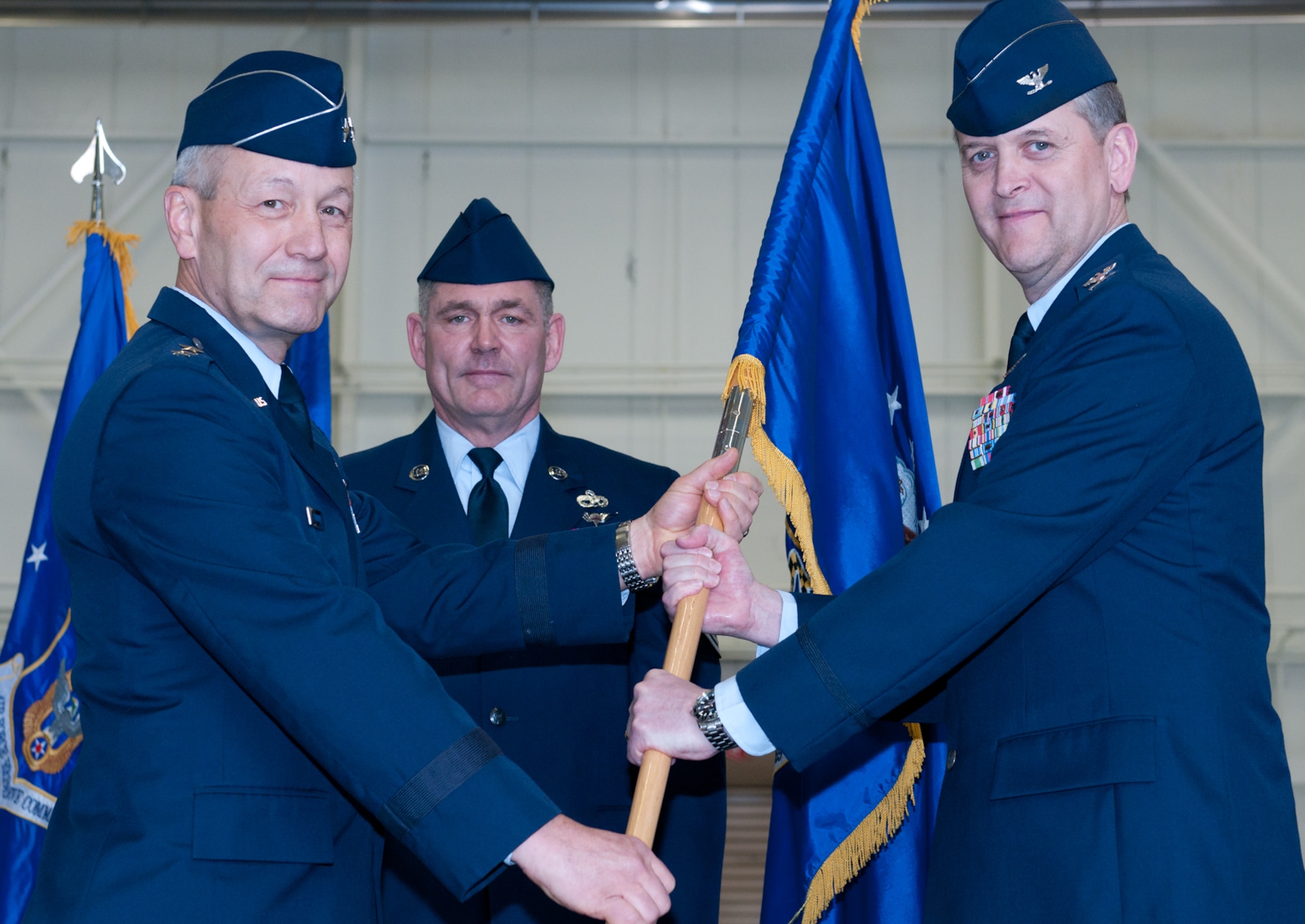 JOINT BASE ANDREWS, Md. -- Maj. Gen. Eric W. Crabtree (far left), 4th Air Force commander, passes the 459th Air Refueling Wing flag to Col. Russell A. Muncy (far right) as Chief Master Sgt. Clifford Van Yahres (center), 459 ARW command chief, looks on in a change of command ceremony here Mar. 5. Colonel Muncy took command of the 459th Air Refueling Wing from Colonel Allman, who retired from the Air Force after 26 years of military service. (U.S. Air Force photo/Staff Sgt. Sophia Piellusch)