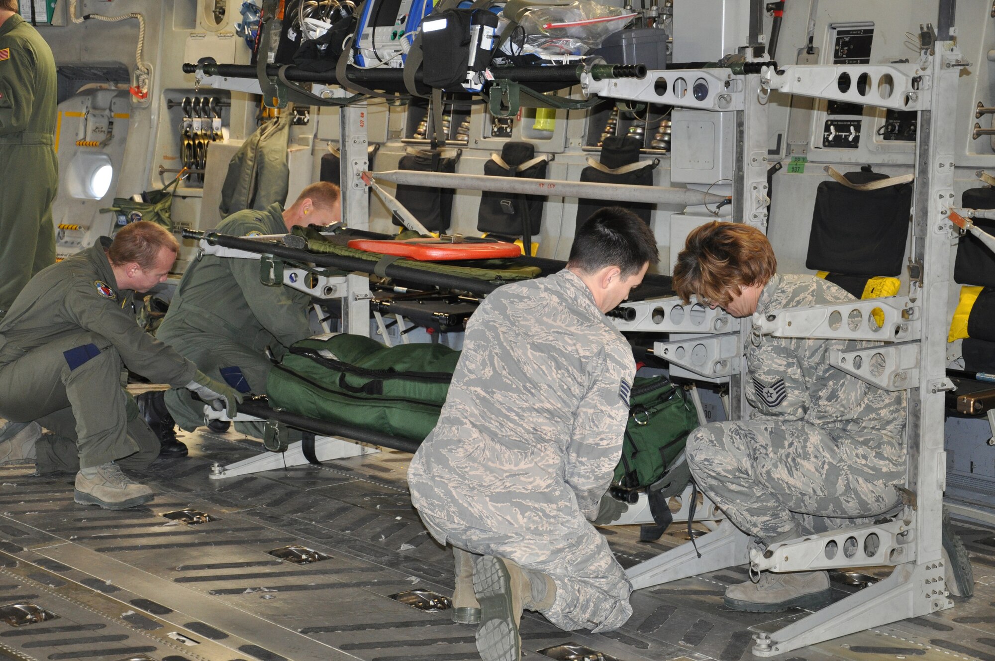WRIGHT-PATTERSON AIR FORCE BASE, Ohio – 445th Aeromedical Evacuation Squadron reservists Tech. Sgt. Mike Flaata and Capt. Dennis Youngpeter (in the background) along with Staff Sgt. Joel Ford and Tech. Sgt. Tamella Hill secure a patient litter onboard a C-17 Globemaster III in preparation for a training flight Feb. 18. This is the first time the 445th AES participated in a training mission with other 445th units (the 89th Airlift Wing and 445th Operations Support Squadron).  (U.S. Air Force photo/Stacy Vaughn)