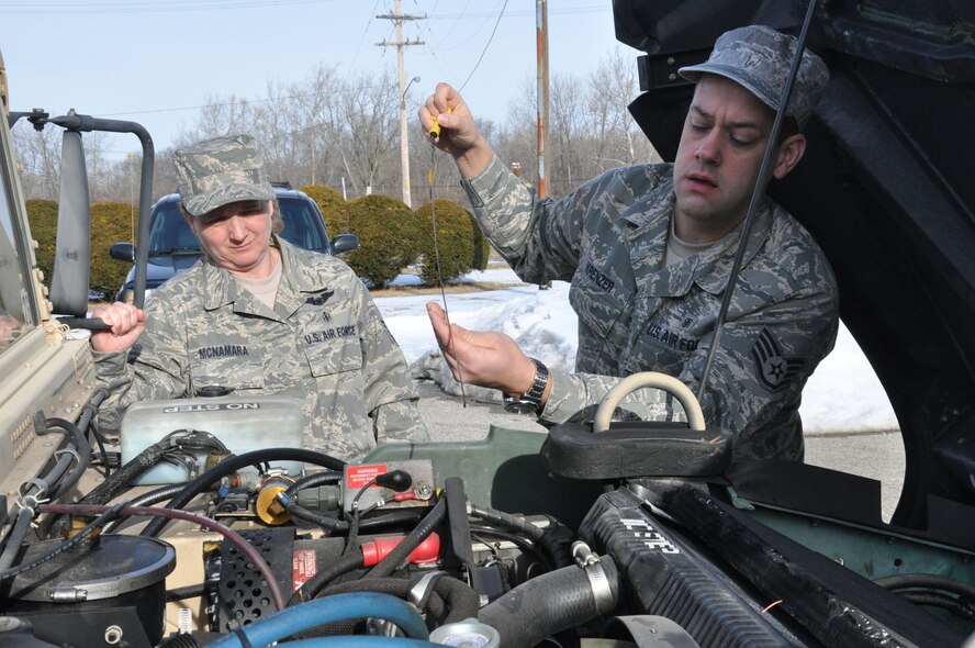 WRIGHT-PATTERSON AIR FORCE BASE, Ohio – Master Sgt. Tina McNamara and Staff Sgt. Wolfgang Krenzer, primary and alternate vehicle control managers for the 445th Aeromedical Evacuation Squadron, check fluid levels on one of the squadron's newly acquired Hum-V's Feb. 13.  Sergeant McNamara was instrumental in the acquisition of the vehicles. (U.S. Air Force photo/Tech. Sgt. Anthony Springer)