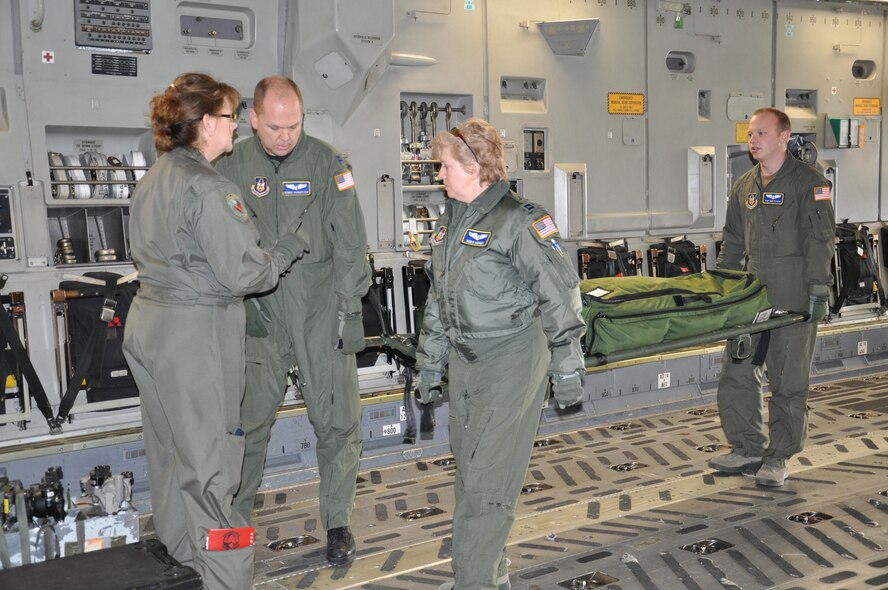 WRIGHT-PATTERSON AIR FORCE BASE, Ohio – Chief Master Sgt. Jodelle Waring, directs (from left to right) Captains Dennis Youngpeter, Robin Kenney and Tech. Sgt. Mike Flaata, all from the 445th Aeromedical Evacuation Squadron, where to place the patient litter as they prepare for a training flight on a C-17 Globemaster III Feb. 18.  This is the first time the 445th AES participated in a training mission with other 445th units (the 89th Airlift Wing and 445th Operations Support Squadron).  (U.S. Air Force photo/Stacy Vaughn)