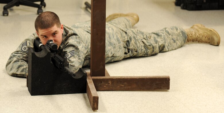 Staff Sgt. Derek Fox, 375th Security Force Squadron CATM instructor, shows a proper prone position Mar.3, 2011 at Scott Air Force Base, Ill.  Scott's CATM instructors train more the 1,500 Airmen a quarter. (U.S Air Force photo/ Airman 1st Class Divine Cox)