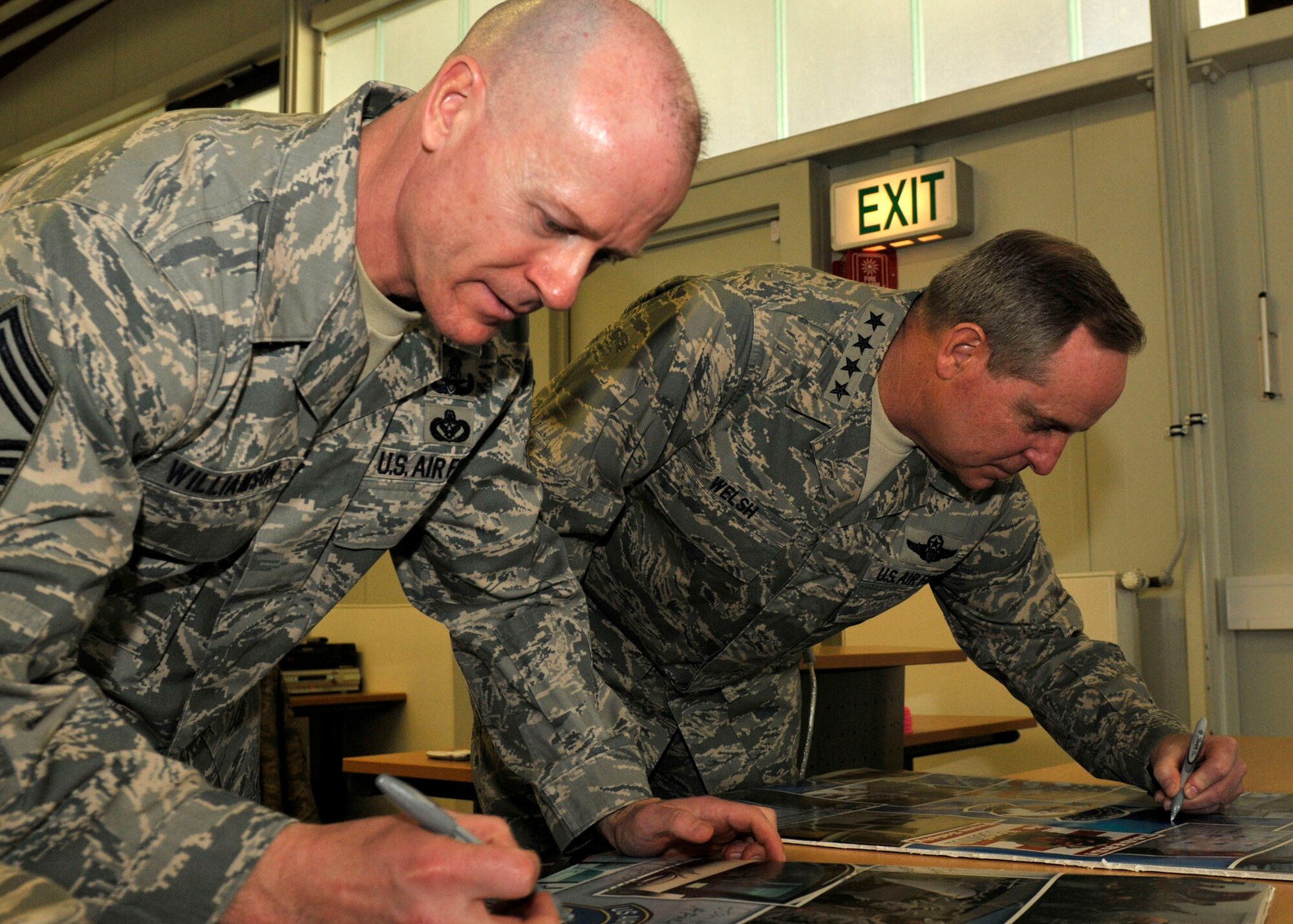 SPANGDAHLEM AIR BASE, Germany— Gen. Mark A. Welsh III, U.S. Air Forces in Europe commander, and Chief Master Sgt. David Williamson, USAFE command chief, sign posters at the 52nd Fighter Wing Safety Office here March 2. The USAFE leaders visited various facilities at Spangdahlem AB to gain a better understanding of the 52nd Fighter Wing. (U.S. Air Force photo/Airman 1st Class Brittney Frees)