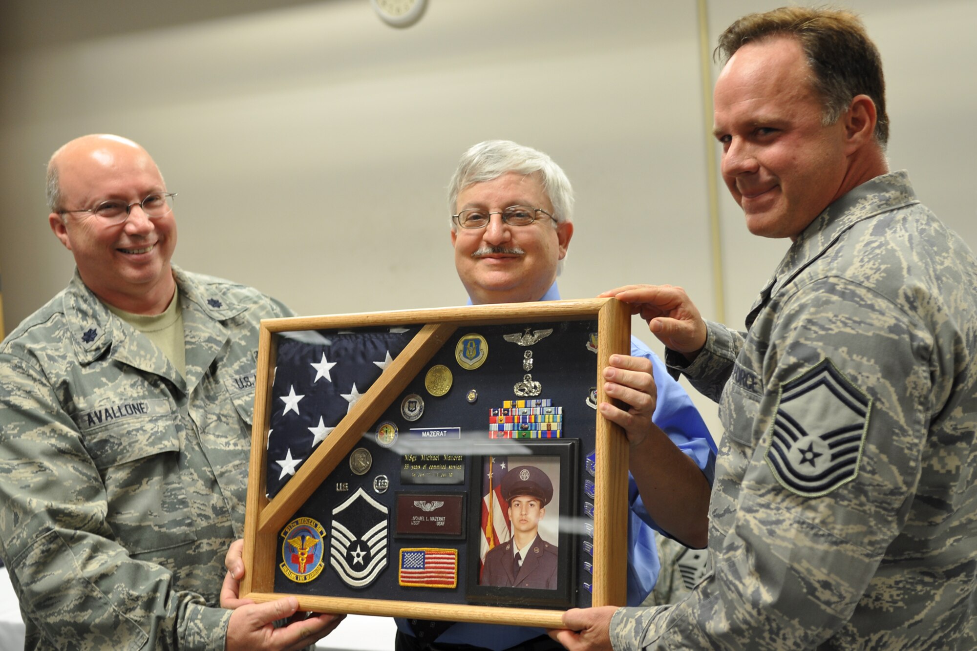 Lt. Col. Gary Avallone, optometrist, 307th Medical Squadron, and Senior Master Sgt. Michael Doelling, medical services attendant, 307th MDS, present a shadow box to Master Sgt. (Ret) Michael Mazerat, during a double retirement ceremony at Barksdale Air Force Base, La., March 5, 2011. Sergeant Mazerat participated in the double retirement ceremony with Colonel Raymond M. Baumgartner, Jr., a dentist with the 307th MDS. (U.S. Air Force photo/Betty Stephens)