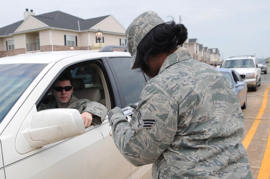 Senior Airman Bobby Masters, 2nd Munitions Squadron, has his I.D. checked by Senior Airman La'Shanette Garrett, 2nd Bomb Wing staff, at the Barksdale Air Force Base, La. gate, March 7. Citizens on Patrol is a new program that provides wing and Air Force Global Strike Command Airmen the opportunity to integrate with other base agencies and involve themselves with law enforcement and base security. (U.S. Air Force photo/Senior Airman Alexandra M. Boutte) (RELEASED)