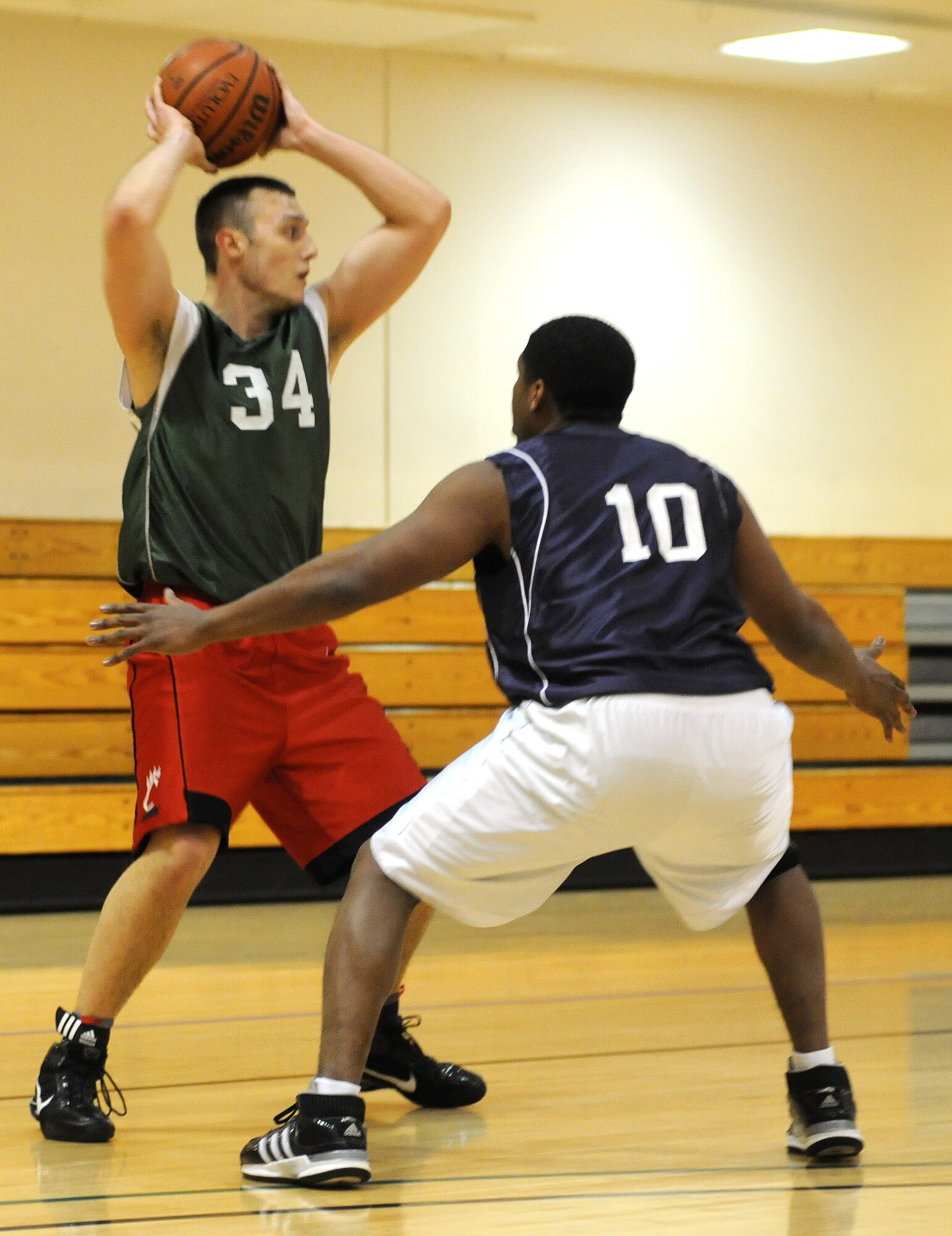 RAF MILDENHALL, England -- Isaac Bell (34), 100th Logistics Readiness Squadron, looks for an open teammate as James Land (10), 100th Aircraft Maintenance Squadron, guards him during the RAF Mildenhall 2011 Intramural Basketball Championship Feb. 4 at the Hardstand Fitness Center.  The 100th LRS beat the 100th Maintenance Group 70-53. (U.S. Air Force photo/Senior Airman Tabitha M. Lee)