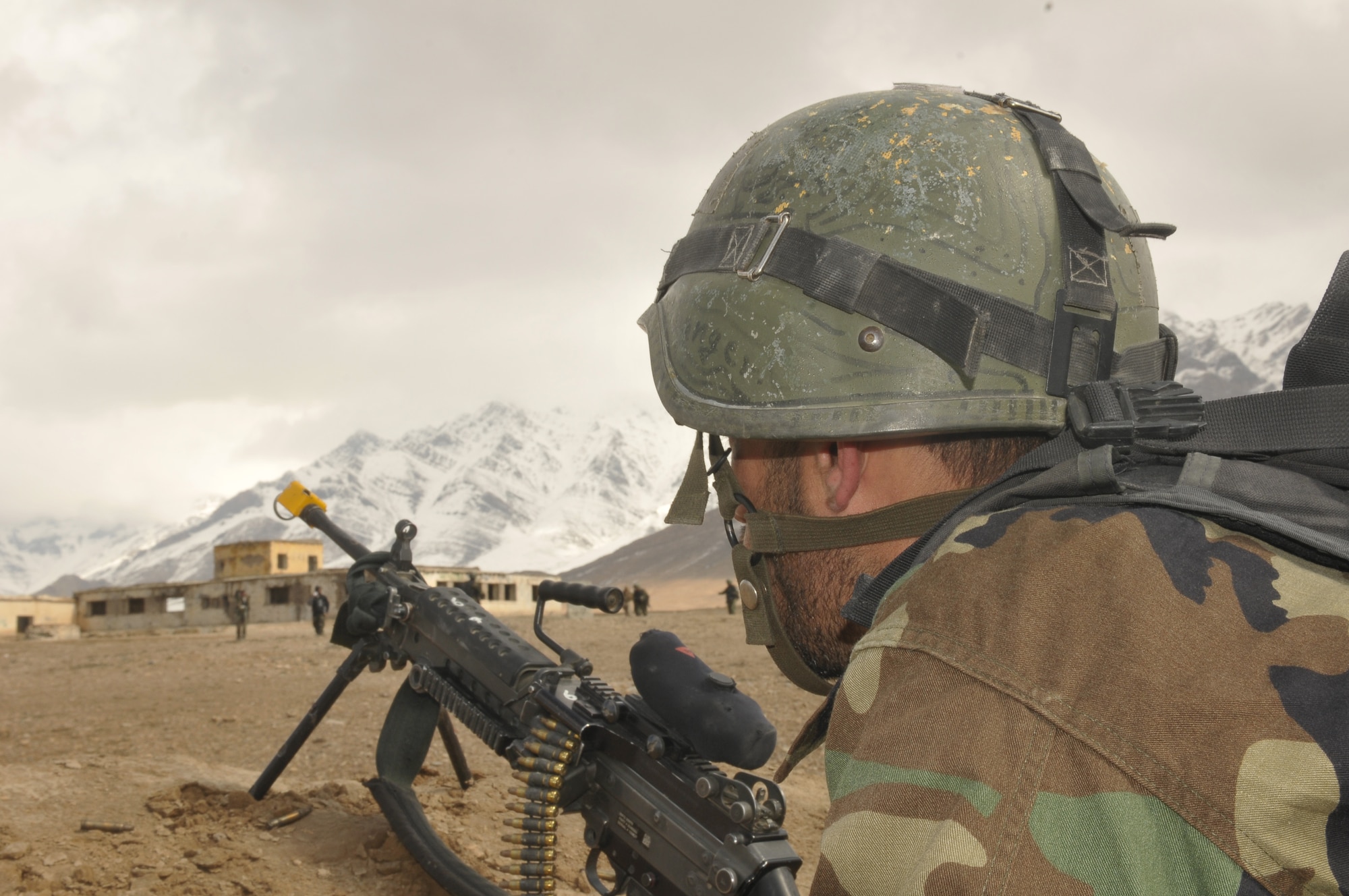 An Afghan National Army Special Forces commando posts security as fellow SF commandos bring forward apprehended enemy combatants during a joint training exercise between the AAF and SF commandos held outside of Kabul March 5. The exercise was the first joint training mission between AAF and SF commandos to see AAF forward observers working with ANA ground forces to provide a link between air and ground initiatives. A precedent that AAF Brig. Gen. Mohammed Barat, the Kabul Wing commander, sees as a major step towards better cooperation and cohesion between the two forces. (U.S. Navy photo by Mass Communications Specialist 2nd Class Vladimir Potapenko).