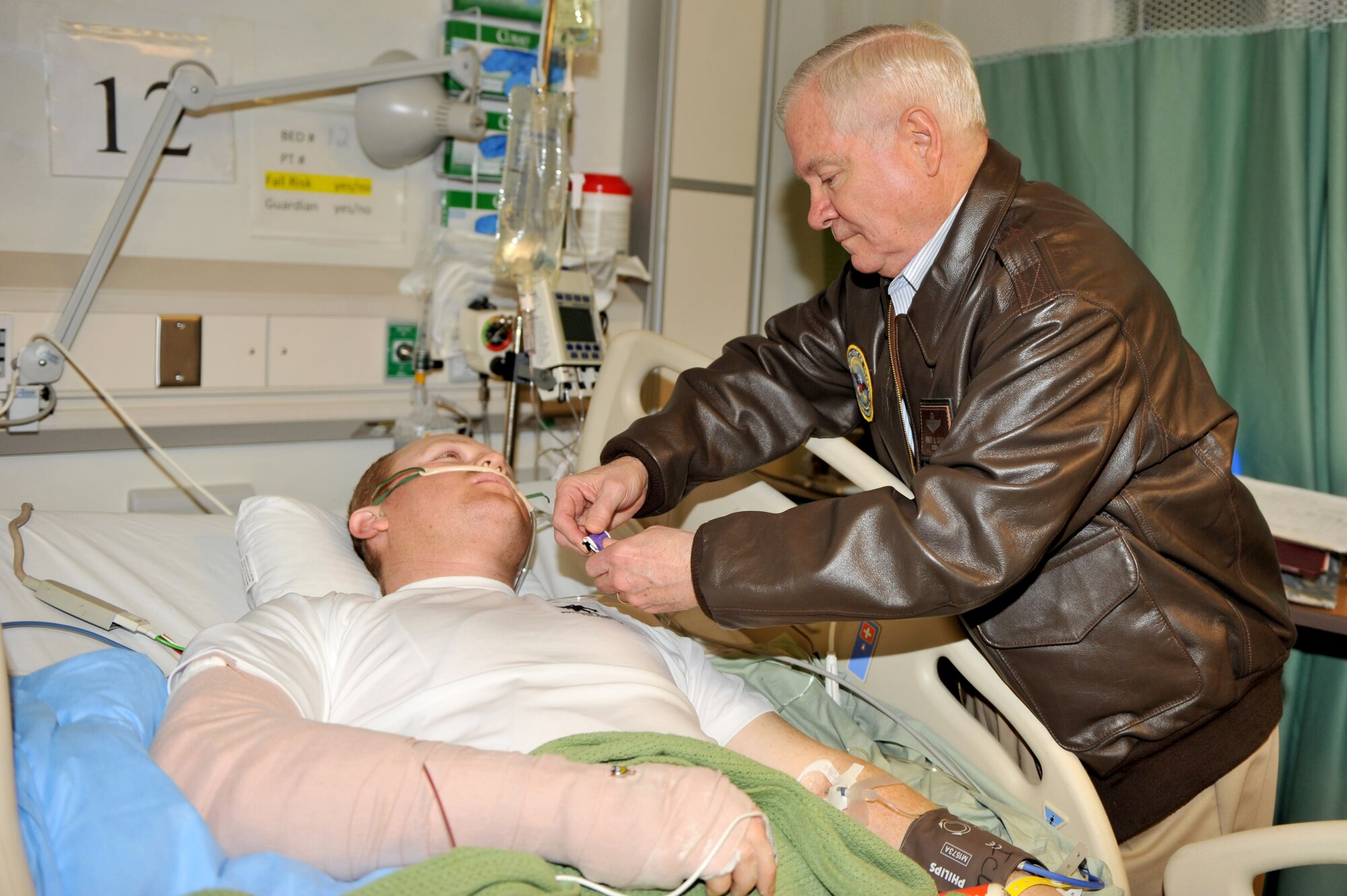 Defense Secretary Robert M. Gates pins a Purple Heart medal on Spc. Steven Dawson at Craig Joint Theater Hospital at Bagram Airfield, Afghanistan, March 7, 2011. (U.S. Air Force photo by Senior Airman Sheila deVera)