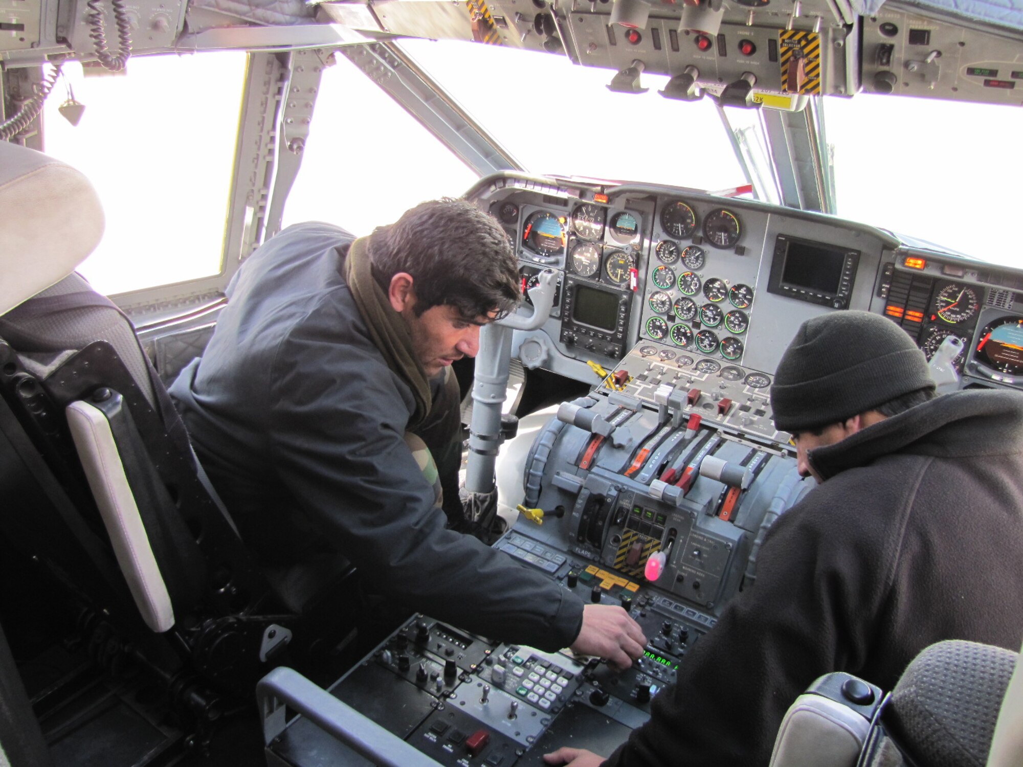 Afghan Air Force Sgt. 1st Class Zaki, one of the initial cadre and the second C-27 AAF avionics maintainer, trains Sgt. Samiullah, a crew chief and engine/body maintainer, on how to operationally check the V/UHF radio during the preflight March 5.  (U.S. Air Force photo by Capt. Rob Leese).