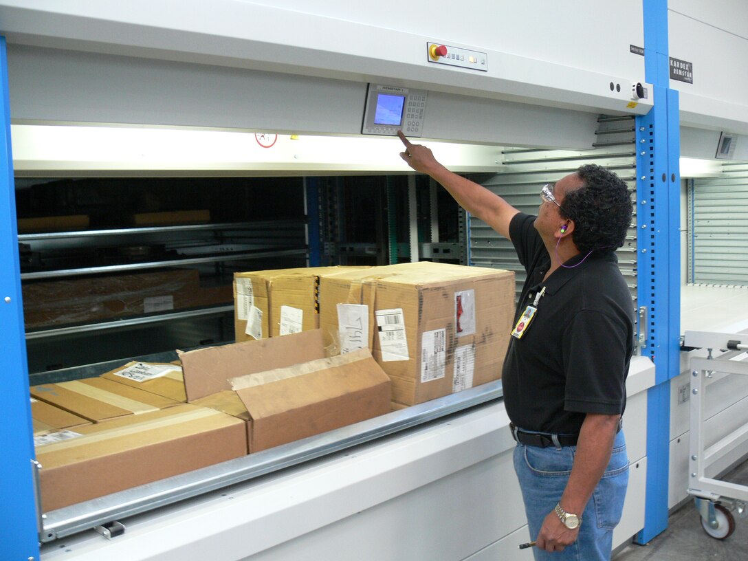 Ricardo Torres, acting supervisor for the Cost Work Center 741 Machine Shop at Maintenance Center Barstow aboard Marine Corps Logistics Base Barstow, Calif., demonstrates how to use the new Kardex Remstar vertical storage carousel inside of the Machine Shop March 7. The storage device will enable workers to more quickly and efficently store and find the parts they need to complete projects in the shop.