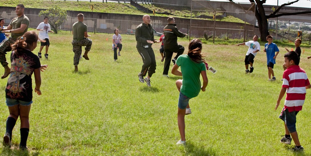 Volunteers with U. S. Marine Corps Forces, Pacific lead Aiea Elementary School students in warm-up exercises March 8 at the school, here.::r::::n::MarForPac Marines assisted the school’s physical education teacher with her classes as part of the command’s ongoing community service efforts. MarForPac officials plan to continue volunteering at numerous schools around the community.
