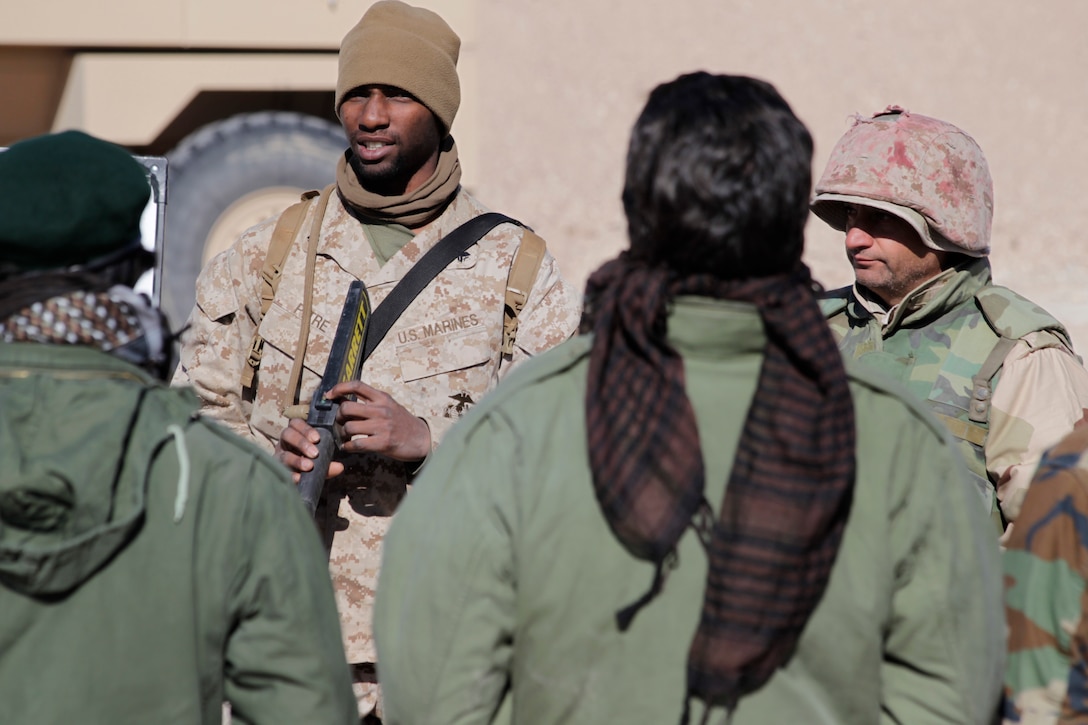 A Marine demonstrates how to search civilians to role players posing as Afghan National Army counterparts before a patrol exercise March 8, 2011 at Range 220.