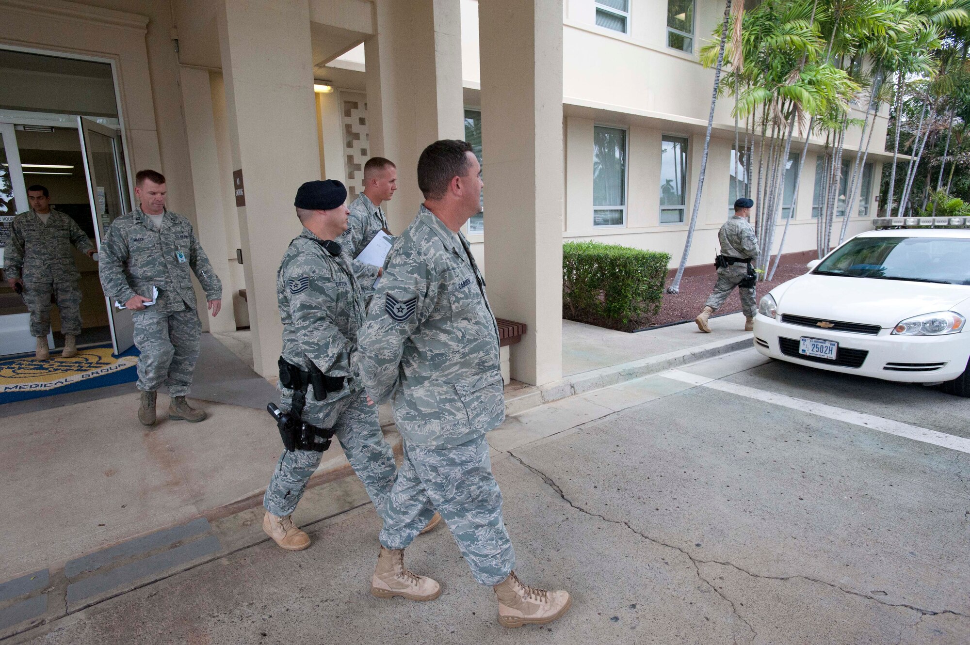 Security Forces personnel arrest Tech. Sgt. Casey Carden, 15th Operations Group intel analyst (center), as he plays the role of an unruly, irate customer at the pharmacy during a portion of the 15th Wing's Operational Readiness Exercise Mar. 3 at Joint Base Pearl Harbor Hickam, Hawaii. The ORE different elements of the 15th Wing's capabilities such as the ability of Airmen to respond to injected scenarios, deploy quickly, and survive and operate in a deployed environment. (U.S. Air Force photo/Staff Sgt. Nathan Allen)