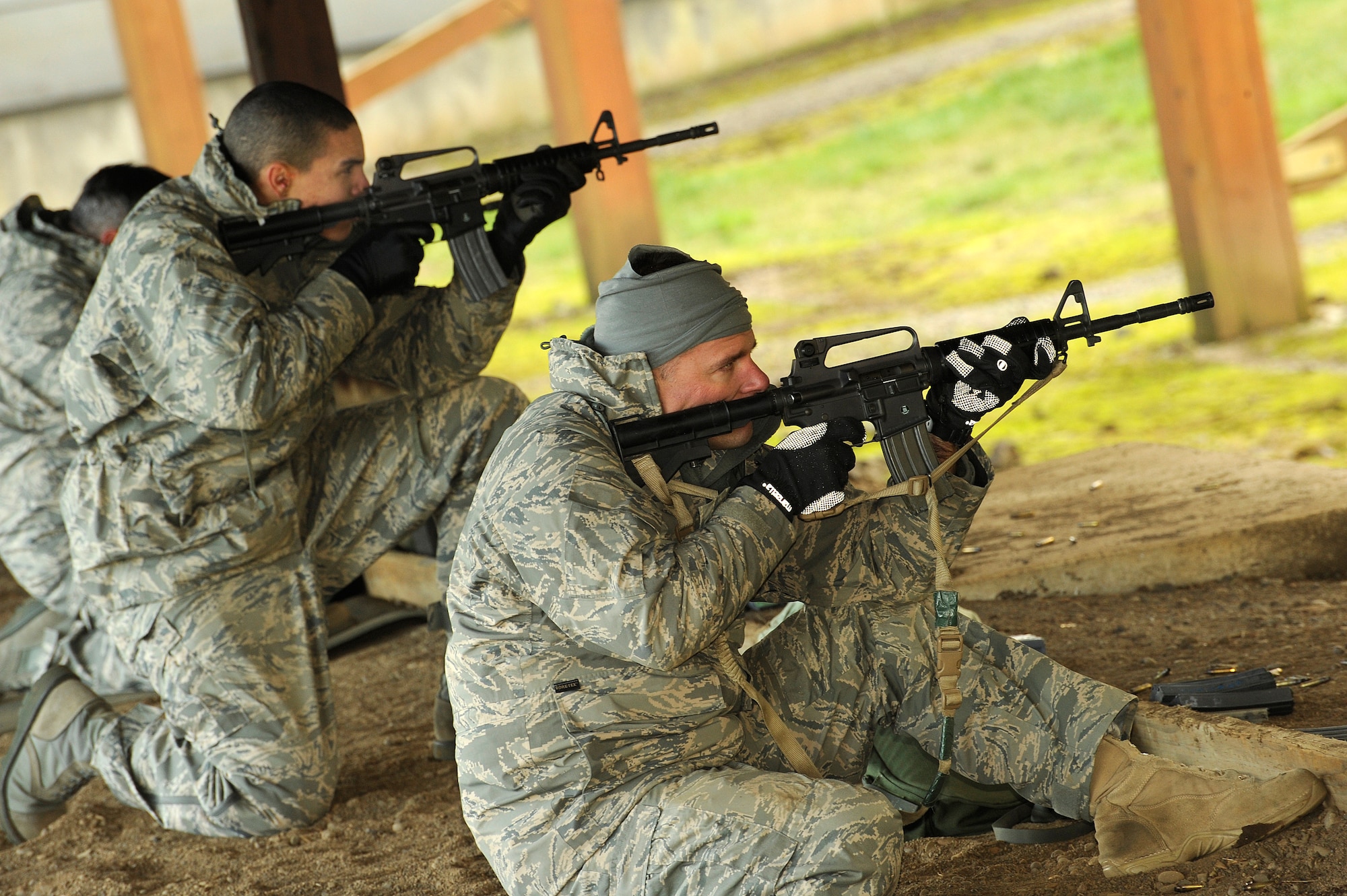 Oregon Air National Airman 1st Class Raymond Potts and Master Sgt. Stanley Brawley of the 116th Air Control Squadron fire their weapons during rounds of qualifying at Camp Adair, Ore., on February 17, 2011. The two Airmen are part of the 116th ACS deploying to the Middle East in March of 2011. (U.S. Air Force photograph by Tech. Sgt. John Hughel, 142nd Fighter Wing Public Affairs)  