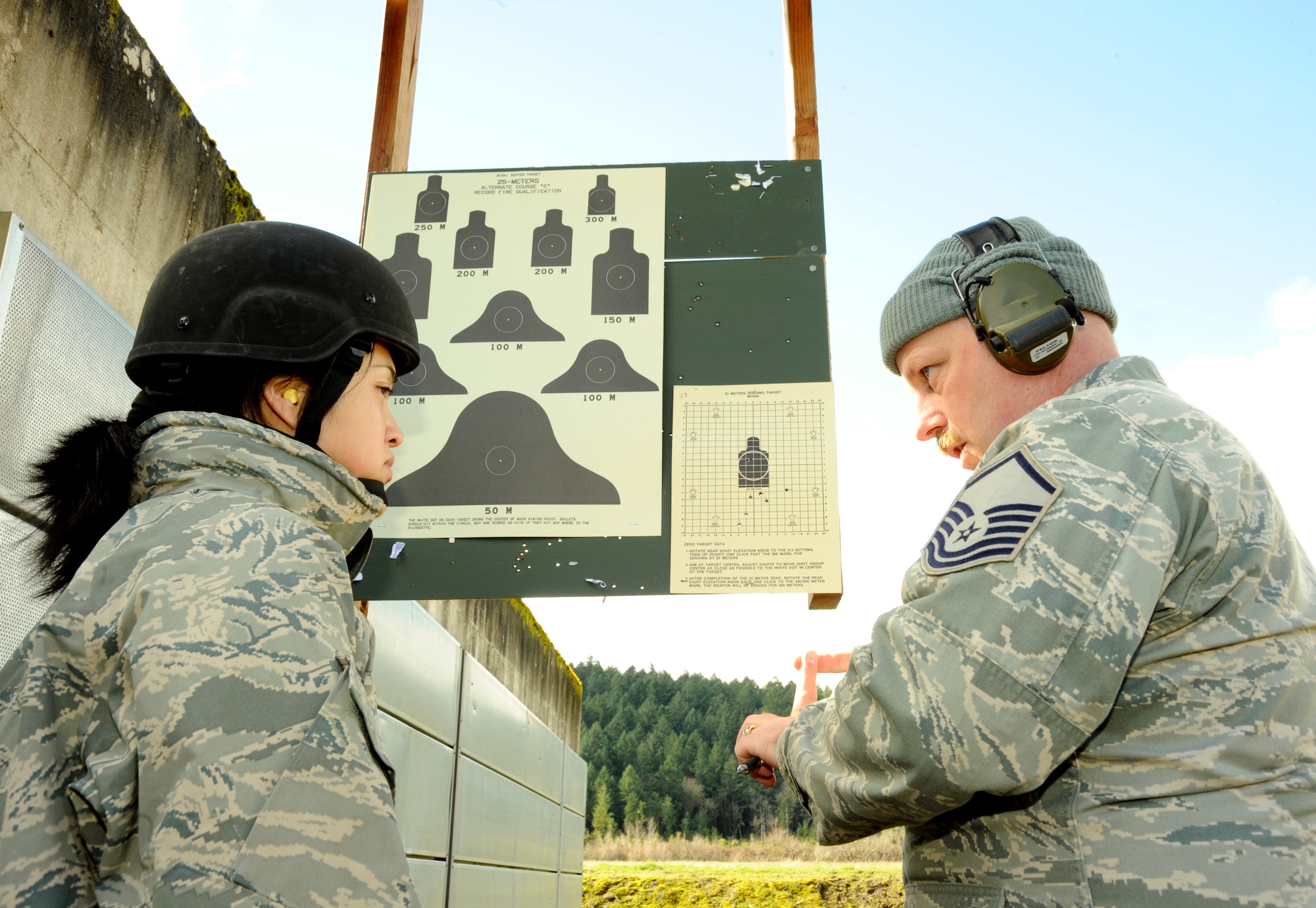Oregon Air National Guard Senior Airman Linda Le listens to feedback by Master Sgt. Paul Persson as she "zero's" her weapon at Camp Adair, Ore., on February 17, 2011. The two are members of the 116th Air Control Squadron based at Camp Rilea, Ore., and are finishing pre-deployment training on the rifle range as part of the unit's deployment to the Middle East in March of 2011. (U.S. Air Force photograph by Tech. Sgt. John Hughel, 142nd Fighter Wing Public Affairs) 