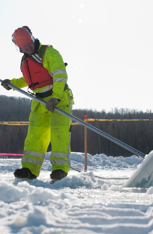 Tech. Sgt. Andrew Perrin adjusts a block of ice bobbing in the water during the annual Ice Operations Exercise held March 1, 2011, at Joint Base Elmendorf-Richardson’s Six Mile Lake in Alaska.  Sergeant Perrin is with JEBR’s 611th Civil Engineer Squadron.  Some 60 people from the 611th CES, the U.S. Coast Guard, the Navy's Supervisor of Salvage, the Alaska Department of Environmental Conservation and the Alaska Chadux Corporation participated in the exercise where participants practice various oil spill clean-up drills. (U.S. Air Force photo/Senior Airman Christopher Gross) 