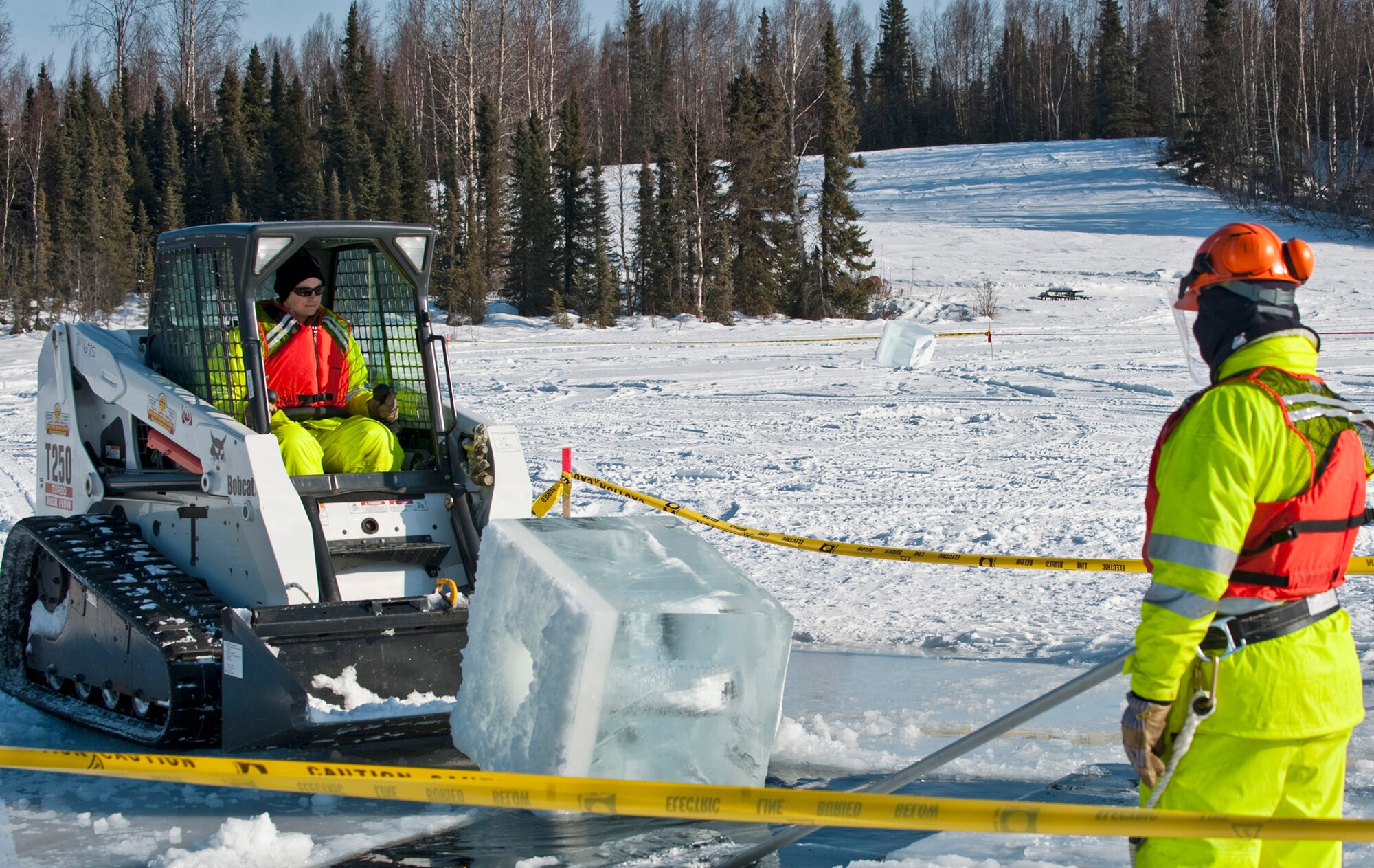 Tech. Sgt. Andrew Perrin looks on as Tech. Sgt. Lucas Clark pushes a block of ice back into the water during the annual Ice Operations Exercise held March 1,2011, at Joint Base Elmendorf-Richardson’s Six Mile Lake in Alaska. Both NCOs are with JBER’s 611th Civil Engineer Squadron.  Some 60 people from the 611th CES, the U.S. Coast Guard, the Navy's Supervisor of Salvage, the Alaska Department of Environmental Conservation and the Alaska Chadux Corporation participated in the exercise where participants practice various oil spill clean-up drills. (U.S. Air Force photo/Senior Airman Christopher Gross)