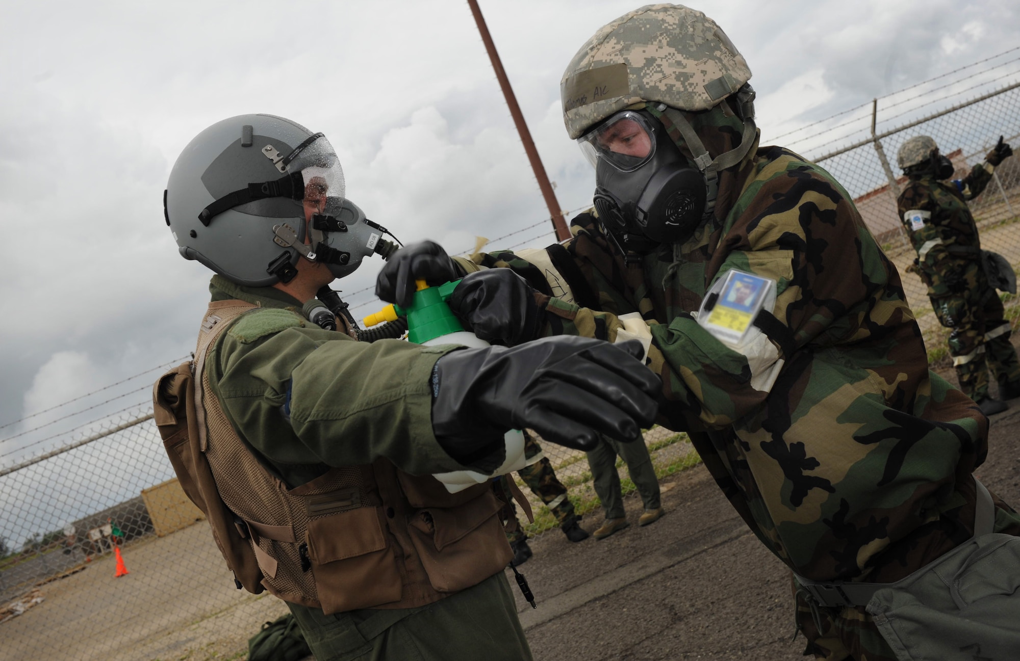 An Airman in mission oriented protective posture gear works to simulate the decontamination of a chemically contaminated aircrew member at Base Y on Joint Base Pearl Harbor-Hickam, Hawaii during the Operational Exercise March 5. The ORE tested Airmen's ability to respond to survive and operate during various wartime conditions. (U.S. Air Force photo/Airman1st Class Lauren Main)