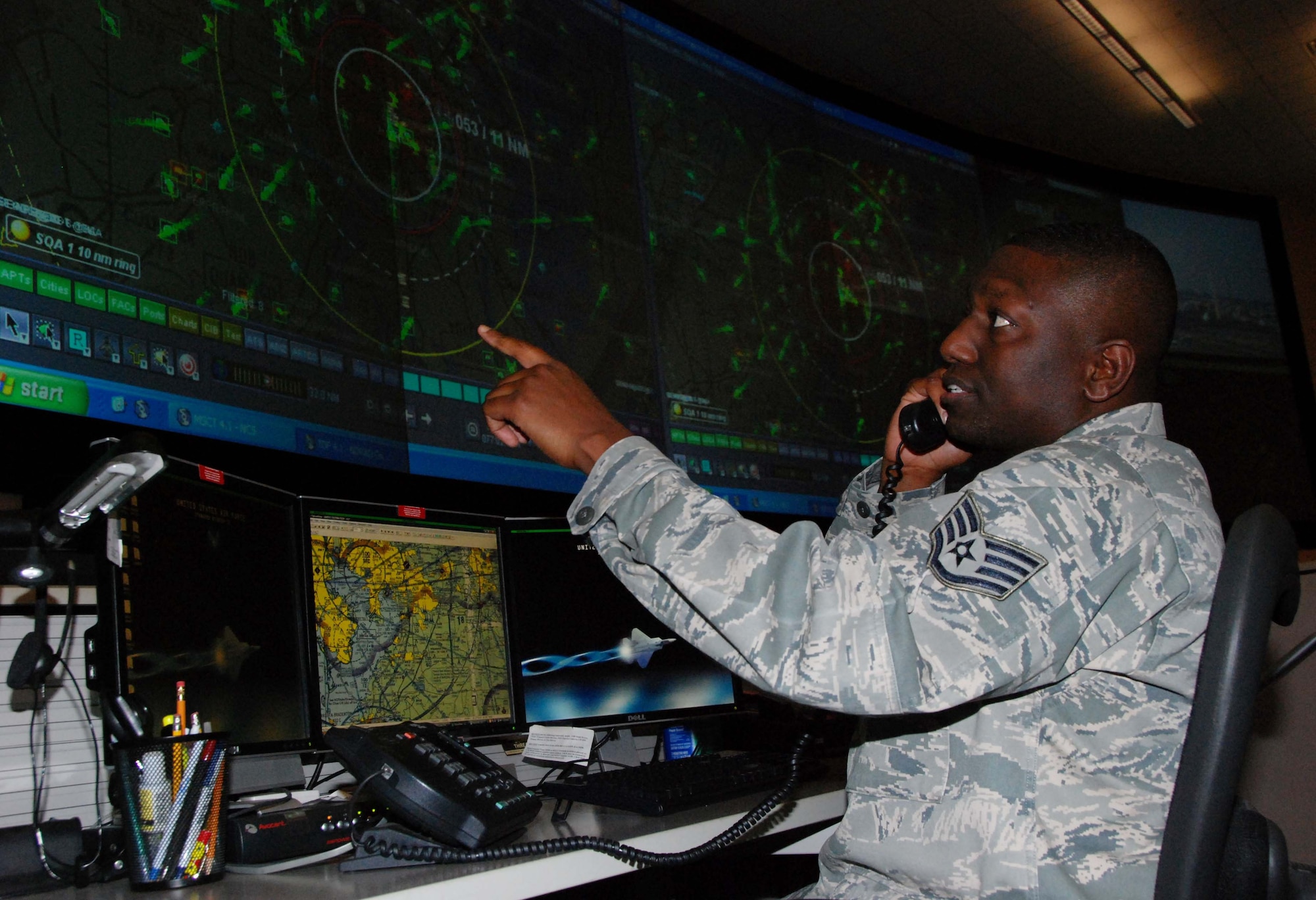 Staff Sgt. Jose Grimes, search and rescue duty officer with the Air Force Rescue Coordination Center at Tyndall Air Force Base, Fla., monitors the radar as he coordinates with another agency during a SAR mission. Sergeant Grimes played a critical role in locating a downed aircraft March 7 near the Canadian border in Maine and coordinating bi-national assets to rescue the aircrew member who survived. (U.S. Air Force photo/Maj. Steve Burke)