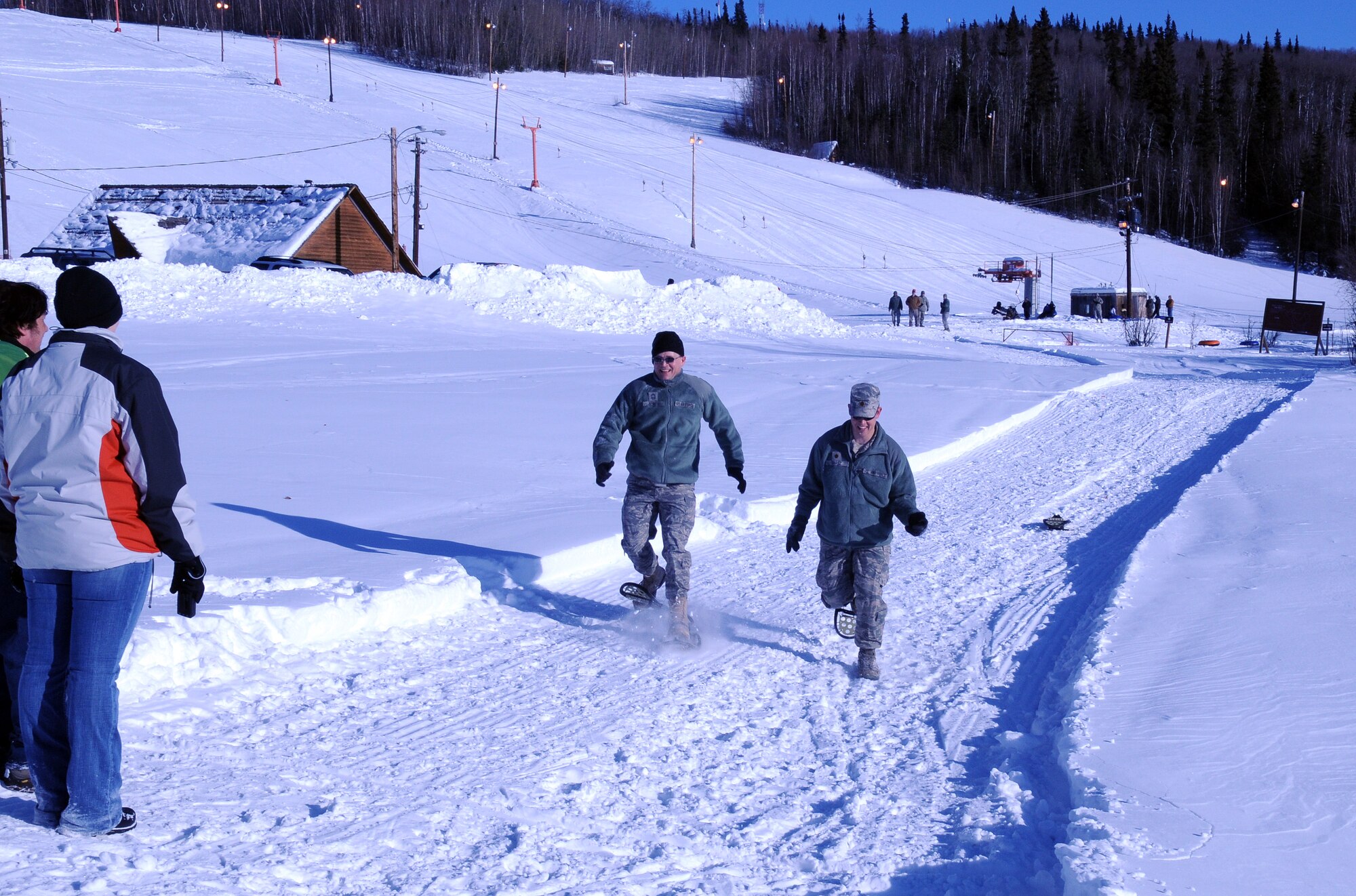 Maj. Robert Ehasz and Chief Master Sgt. James North snowshoe March 4, 2011, Eielson Air Force Base, Alaska. The Airmen participated in the commanders and chiefs race that involved tubing down the hill and snowshoeing to the finish line. Major Ehasz is the 354th Maintenance Squadron commander. Chief North is the 354th Medical Group superintendent. (U.S. Air Force Photo/Airman 1st Class Janine Thibault)
