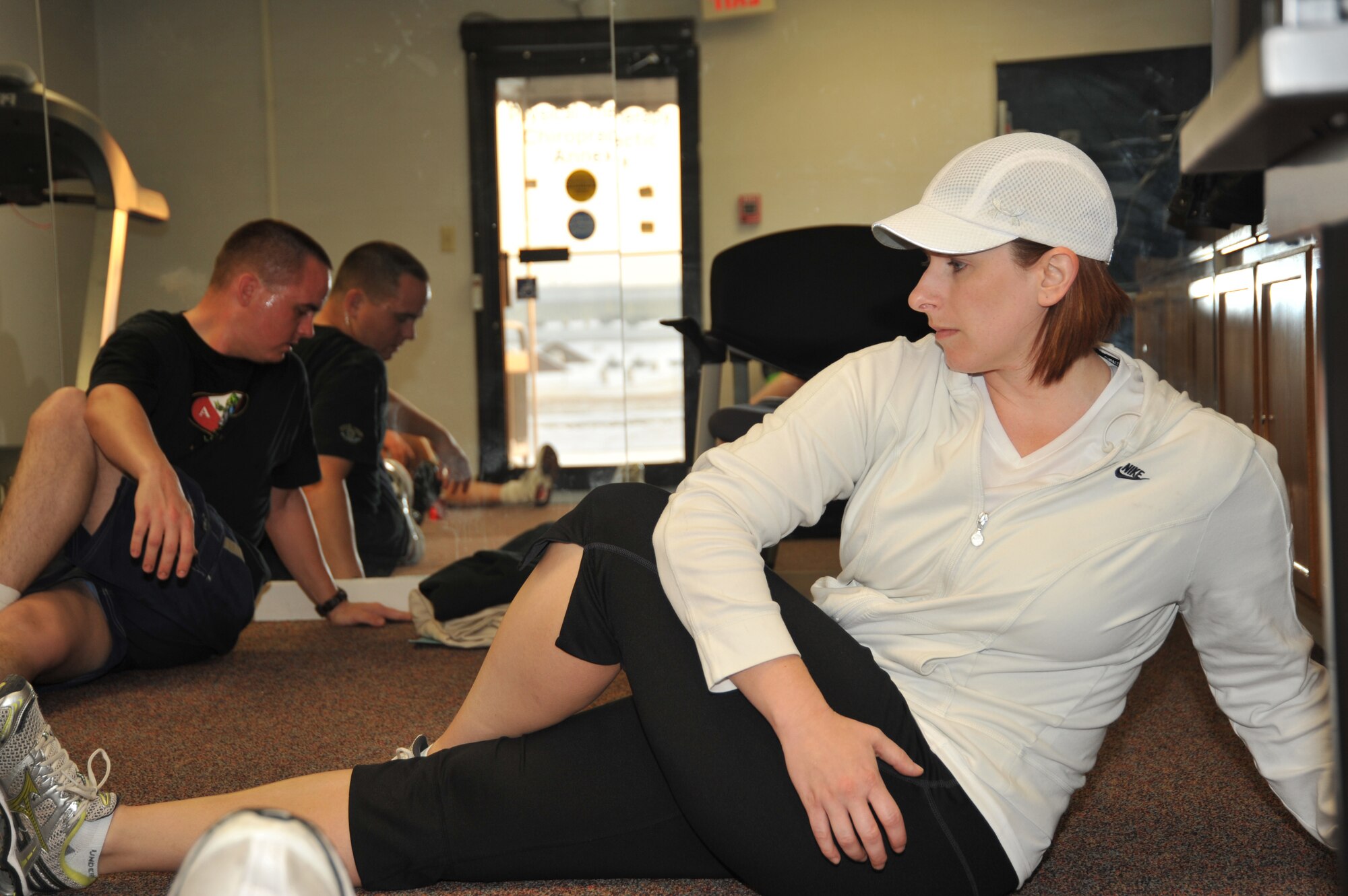 OFFUTT AIR FORCE BASE, Neb. - Marcy Jameson, HAWC Flight Chief & Exercise Physiologist, leads the Get Fit Run class in some post-running stretching inside the Offutt Field House. After the stretching, she logged each runner's time. U.S. Air Force photo by D.P. Heard