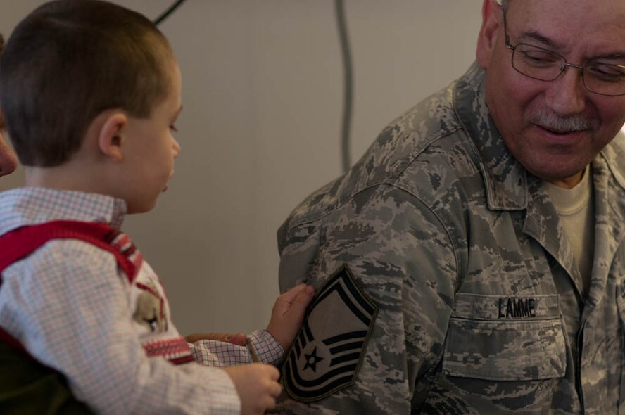 Chief Master Sergeant Darrel Lamme’s grandson, Mitchell, helps his grandmother put on his new stripes during a promotion ceremony, Saturday, March 5, 2011 at the 139th Airlift Wing, St. Joseph, Mo. Mr. Lamme was promoted to Chief Master Sgt. in the Missouri Air National Guard.  (U.S. Air Force photo by Airman 1st Class Kelsey Stuart/Released)