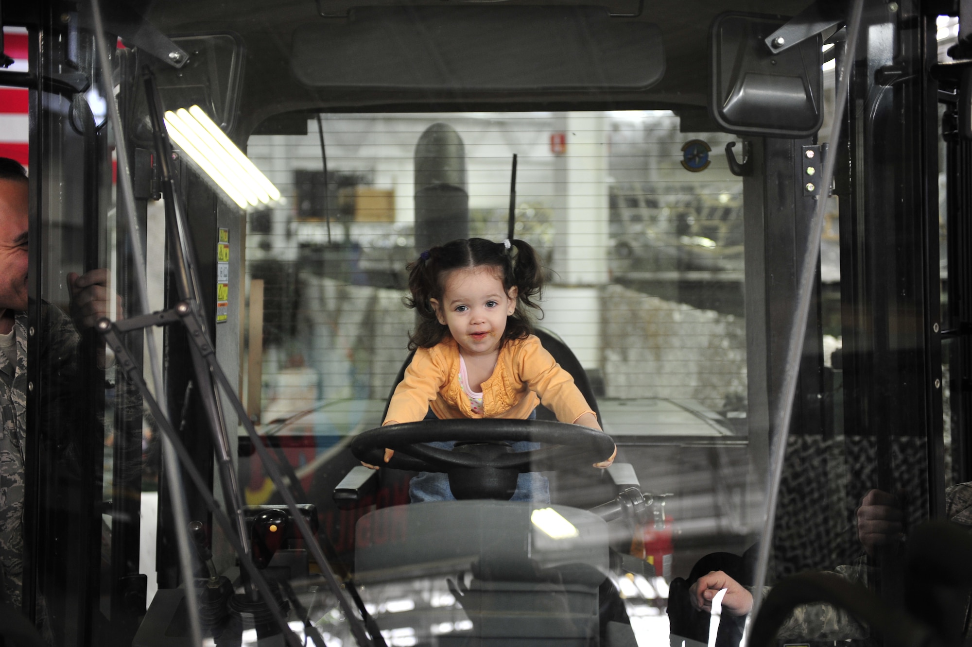 Katherine Burrows, two-year-old daughter of Master Sgt Stephen Burrows, 621st Contingency Operations Support Group first sergeant, “drives” a 10,000-pound capacity all-terrain forklift during the 621st Contingency Response Wing’s family open house at the Joint Base McGuire-Dix-Lakehurst, N.J. Global Reach Deployment Center March 4.  The event included activities and food for the families alongside demonstrations of the specialized equipment used by the unit to provide emergency global mobility support to humanitarian crises and national defense operations. (U.S. Air Force photo/Tech. Sgt. Parker Gyokeres) (Released)