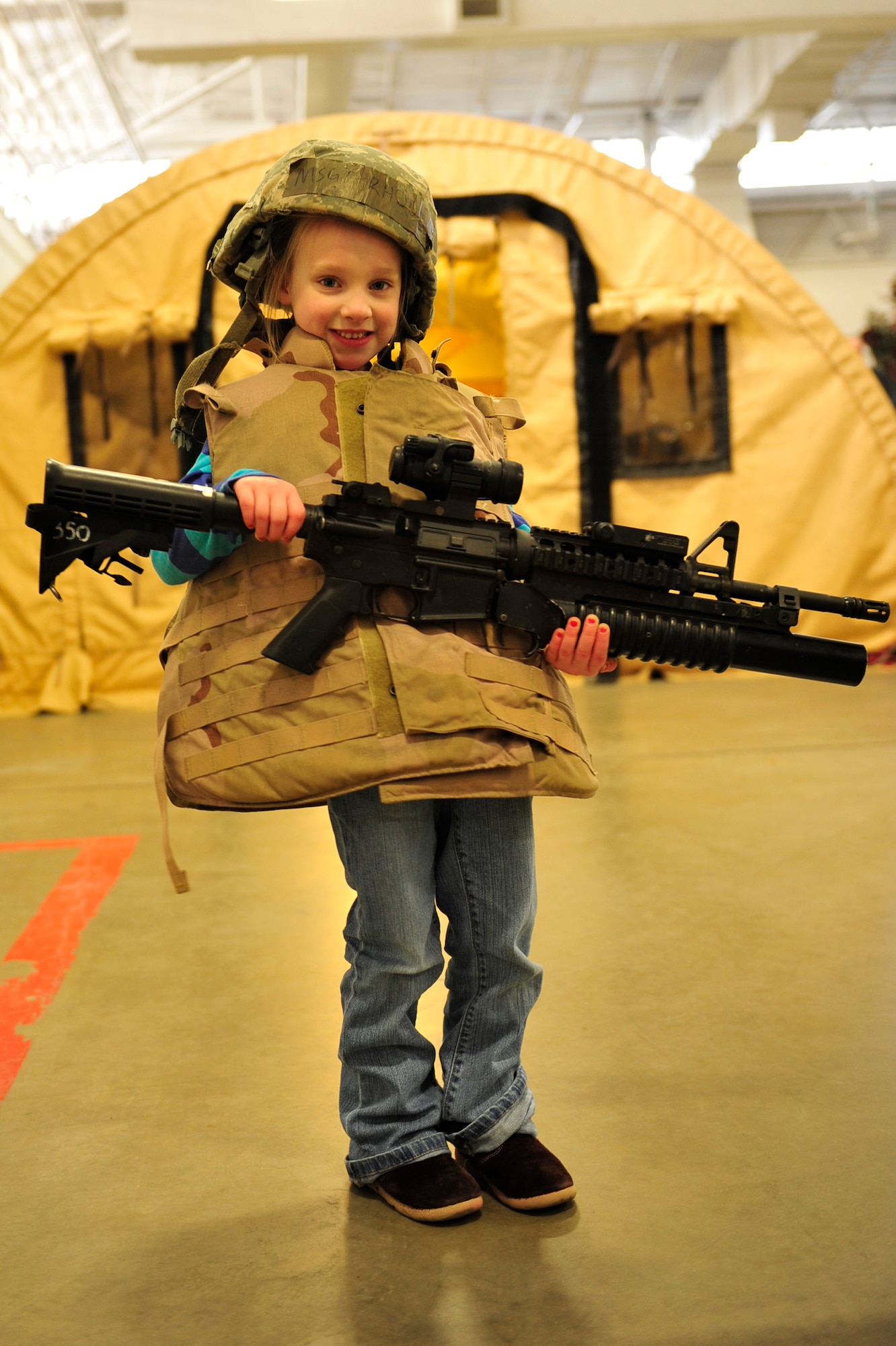 Adeline White, six-year-old daughter of Tech. Sgt. Aaron White, 819th Global Support Squadron force protection supervisor, poses with a M-4/M203 grenade launcher and personal protective armor during the 621st Contingency Response Wing’s family open house at the Joint Base McGuire-Dix-Lakehurst, N.J. Global Reach Deployment Center March 4.  The event included activities and food for the families alongside demonstrations of the specialized equipment used by the unit to provide emergency global mobility support to humanitarian crises and national defense operations. (U.S. Air Force photo/Tech. Sgt. Parker Gyokeres) (Released)