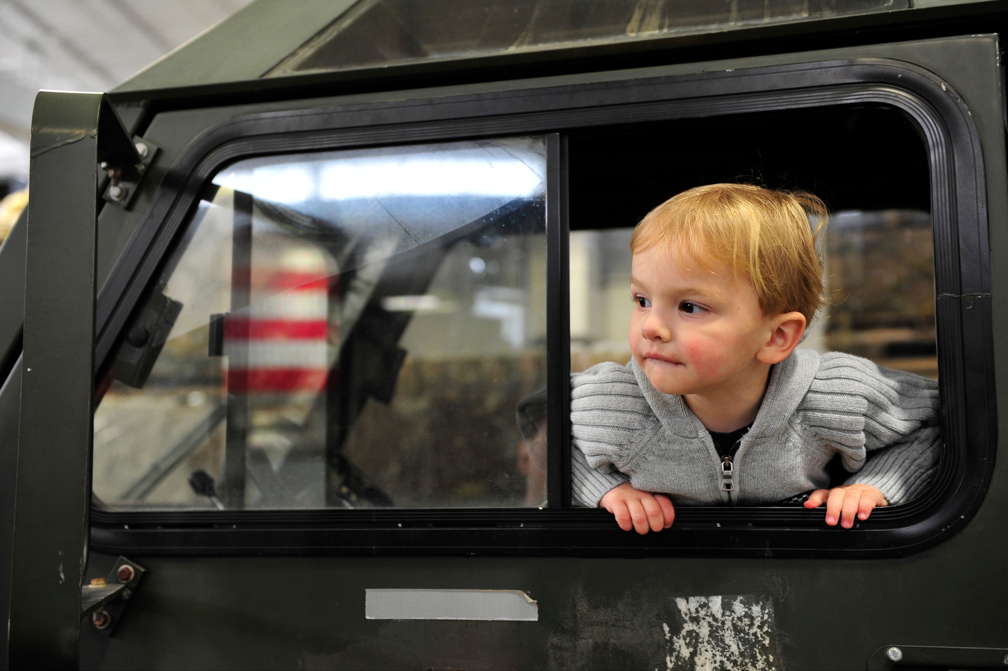 Two-year-old Noah Huston looks out of the cabin window of a next-generation small loader during the 621st Contingency Response Wing’s family open house at the Joint Base McGuire-Dix-Lakehurst, N.J. Global Reach Deployment Center March 4.  Noah’s father is Staff Sgt. Zachary Huston, 817 Global Mobility Squadron mobile command and control craftsman. (U.S. Air Force photo/Tech. Sgt. Parker Gyokeres) (Released)