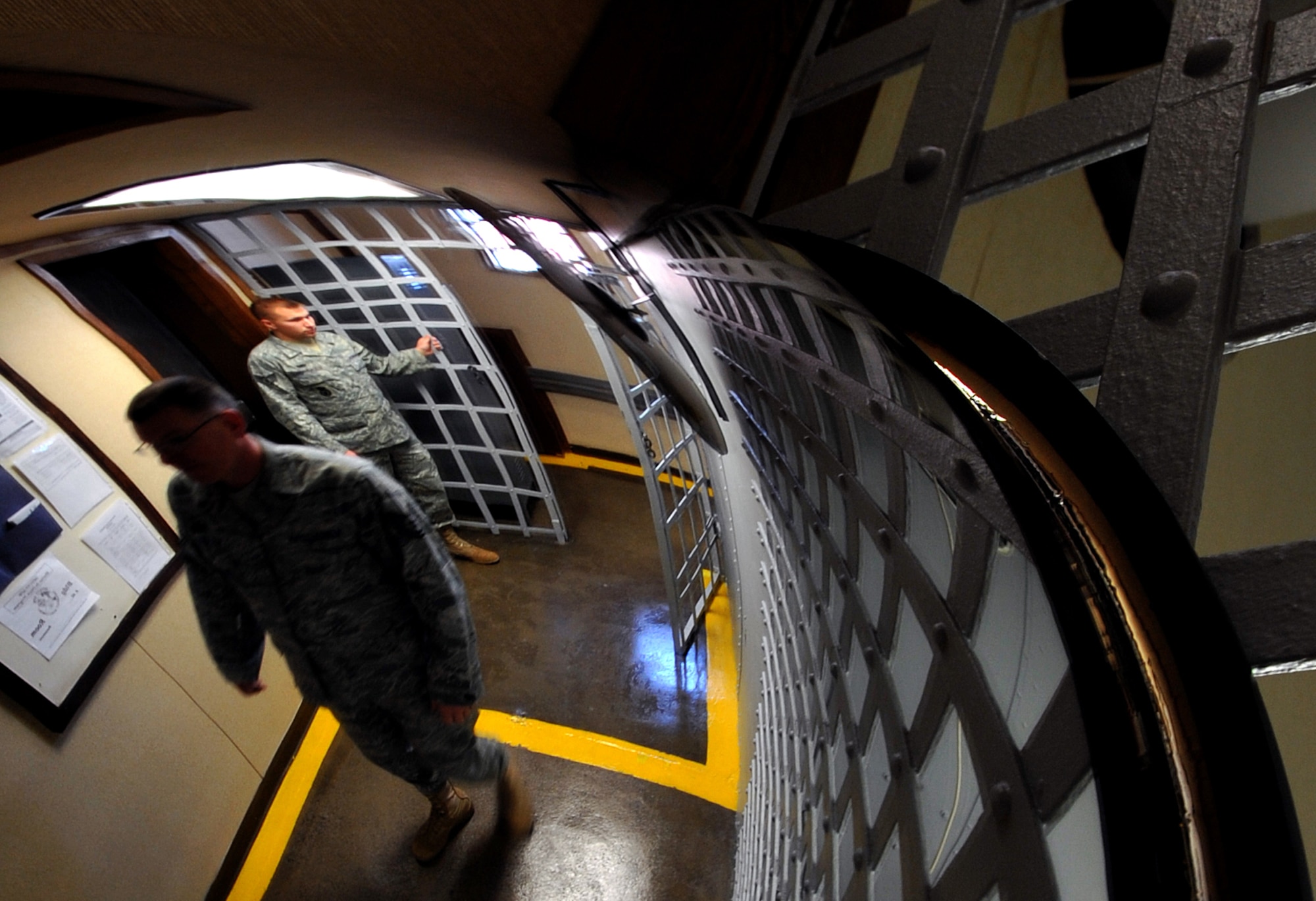 OFFUTT AIR FORCE BASE, Neb. - Staff Sgt. Andrew A. Blascyk, a confinement guard, and Tech Sgt. Raymond C. Kubiaczyk, NCO in charge of confinement for the 55th Security Forces Squadron, prepare to secure the temporary cell space gate on March 3. The facility is the oldest operational jail west of the Mississippi River and can house up to 15 inmates. U.S. Air Force photo by Jeff Gates