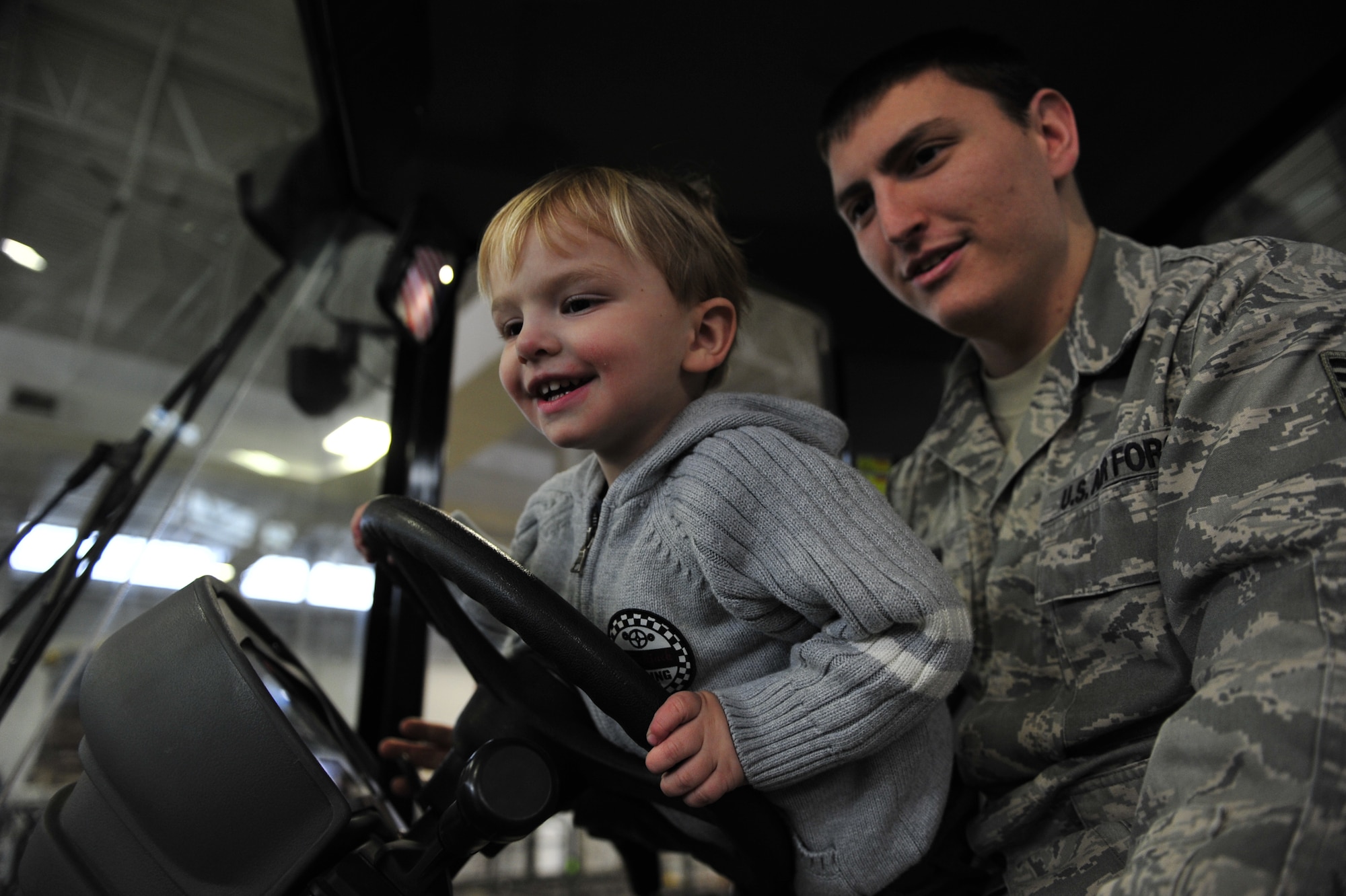 Two-year-old Noah Huston sits in his dad’s lap at the wheel of a 10,000-pound capacity all-terrain forklift during the 621st Contingency Response Wing’s family open house and capability demonstration at the Joint Base McGuire-Dix-Lakehurst, N.J. Global Reach Deployment Center March 4.  Noah’s father is Staff Sgt. Zachary Huston, 817 Global Mobility Squadron mobile command and control craftsman. (U.S. Air Force photo/Tech. Sgt. Parker Gyokeres) (Released)