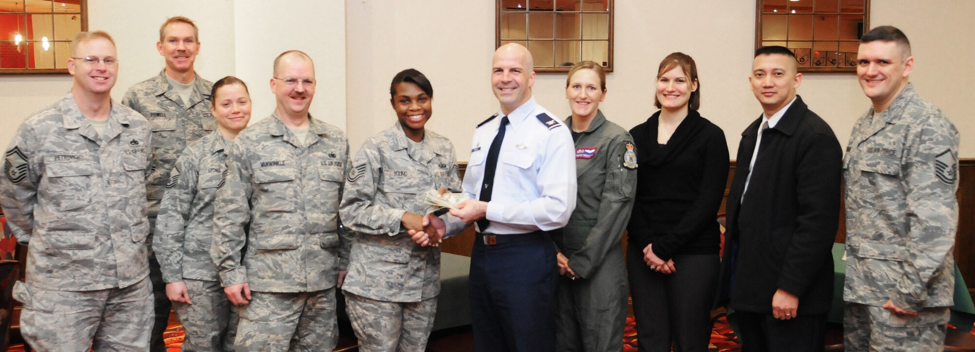 RAF MILDENHALL, England -- Col. Chad Manske, 100th Air Refueling Wing commander (light blue shirt), presents his donation for the Air Force Assistance Fund to Tech. Sgt. Aronda Young, 100 ARW staff agencies AFAF representative, along with other AFAF unit representatives at the Galaxy Club March 3, 2011. The AFAF helps raise money for the Air Force Village, the Air Force Aid Society, the General and Mrs. Curtis E. LeMay Foundation, and the Air Force Enlisted Village. The campaign runs on here until March 18. To donate, contact a unit representative. (U.S. Air Force photo/Staff Sgt. Thomas Trower)