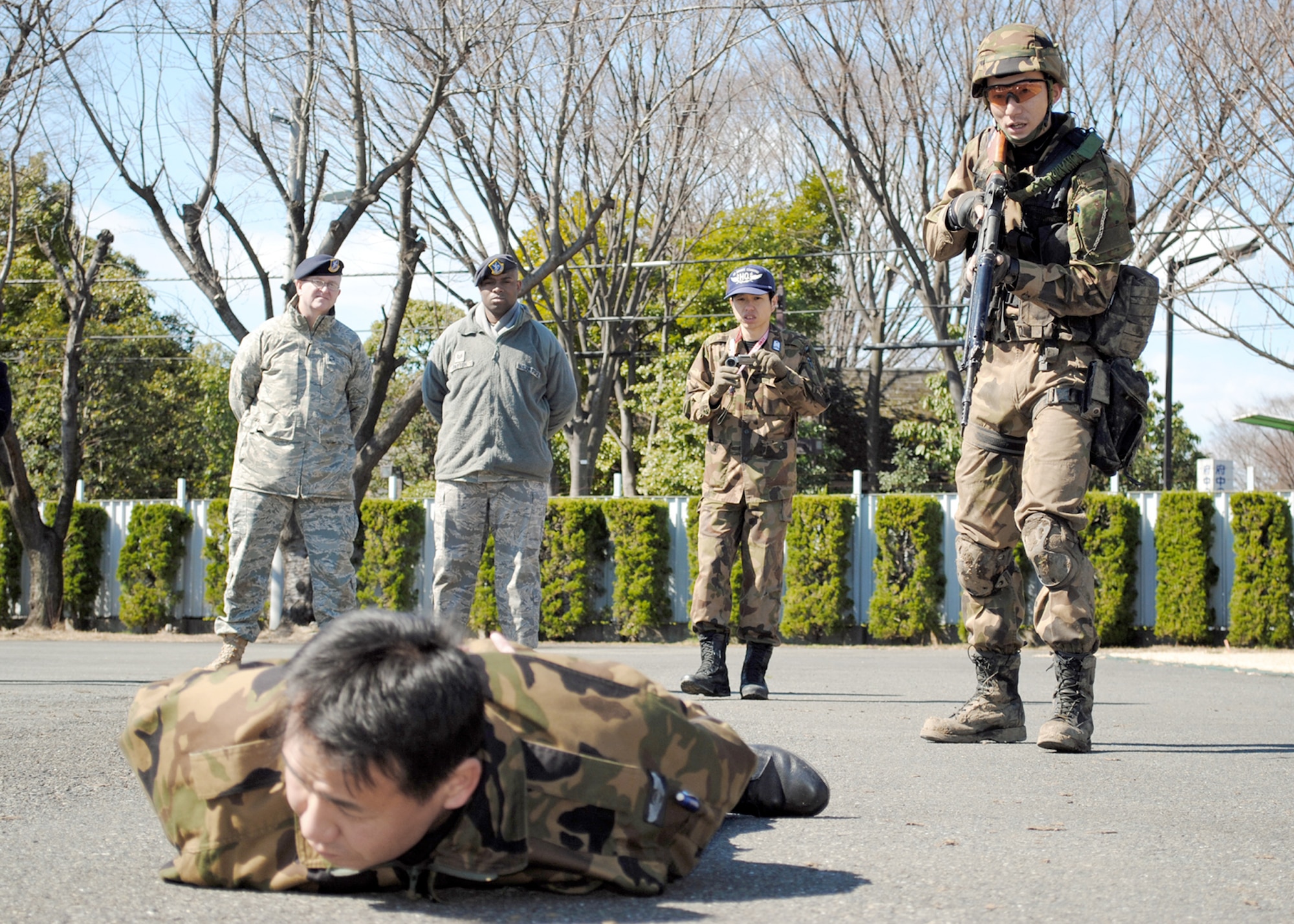 Security guards from the Japan Air Self Defense Force practice searching a suspicious person during the vehicle challenge block of training March 4, 2011, at Yokota Air Base, Japan. Airmen from 5th Air Force and 374th SFS are helping JASDF transform its security guard training and operations into something more similar to U.S. Air Force security forces as JASDF prepares to stand up its new Base Defense Development and Training Squadron. (U.S. Air Force photo/Capt. Will Powell)