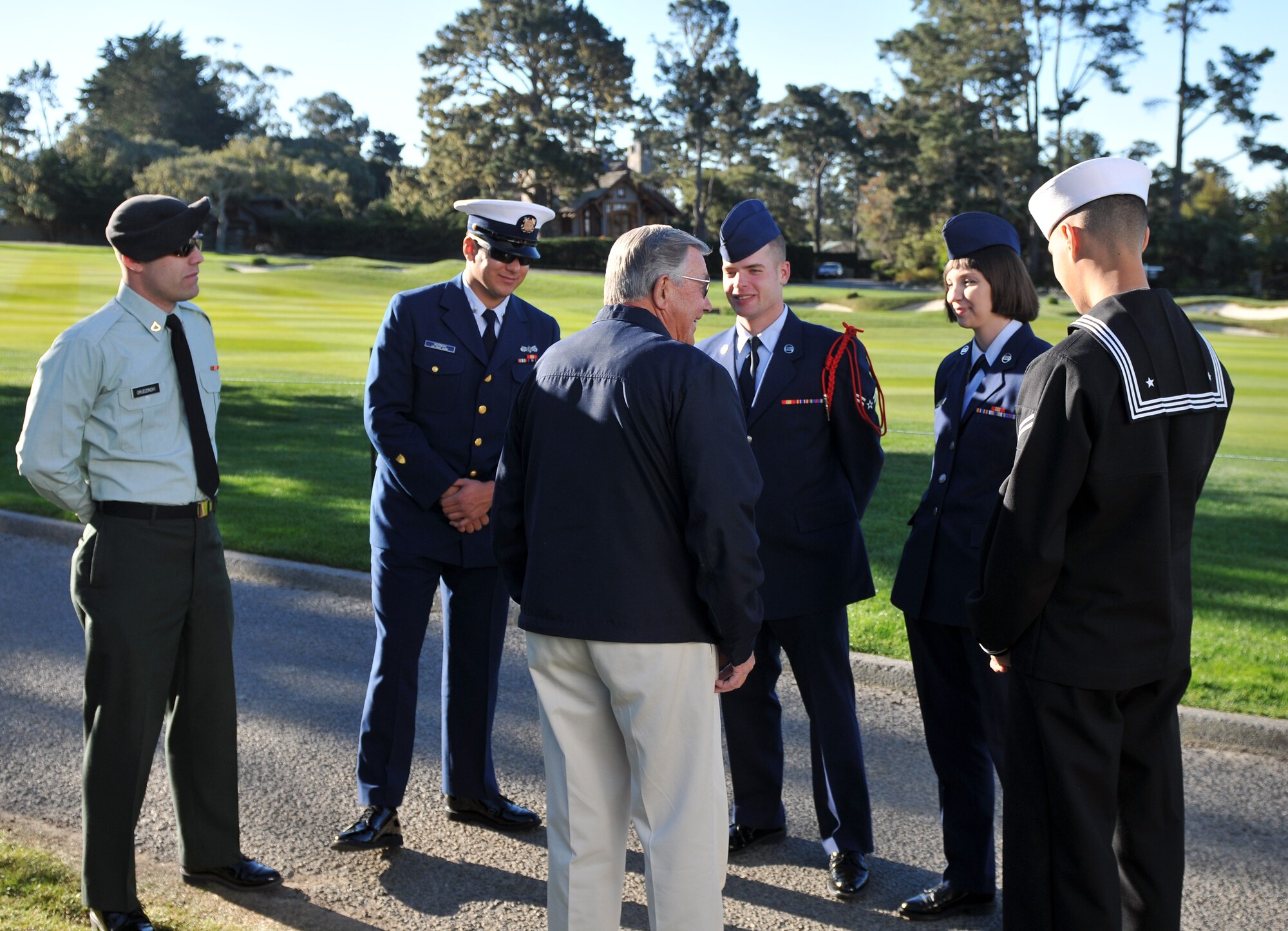 PEBBLE BEACH, Calif. -  Bob Sparks, coordinator of the Military Appreciation hospitality tent at the AT&T Pebble Beach Pro-Am, speaks with service members at the Pebble Beach golf course on the morning of Feb. 12. Representatives from the Army, Navy, Air Force and Coast Guard were on hand to tend the U.S. flag adorned, hole-15 pin during the final two rounds of the nationally televised golf tournament. (U.S. Air Force photo/Steven L. Shepard)