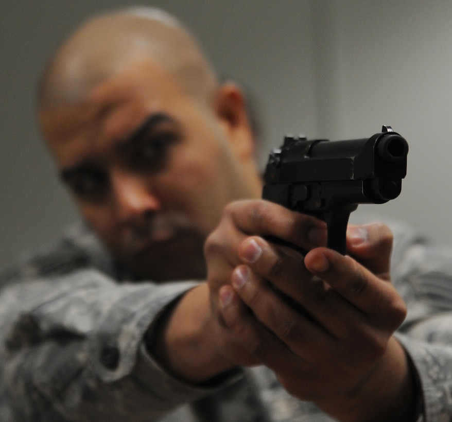 Technical Sgt. Erik Rodriguez, 11th Security Forces Squadron flight chief, ensures his M-9 is working properly by simulating firing it while attending a combat arms class at Joint Base Andrews March 2. After security forces members disassemble, inspect and reassemble their weapons, they must accomplish a function check to ensure all parts of their weapon are working correctly. (U.S. Air Force photo by Senior Airman Melissa V. Brownstein)