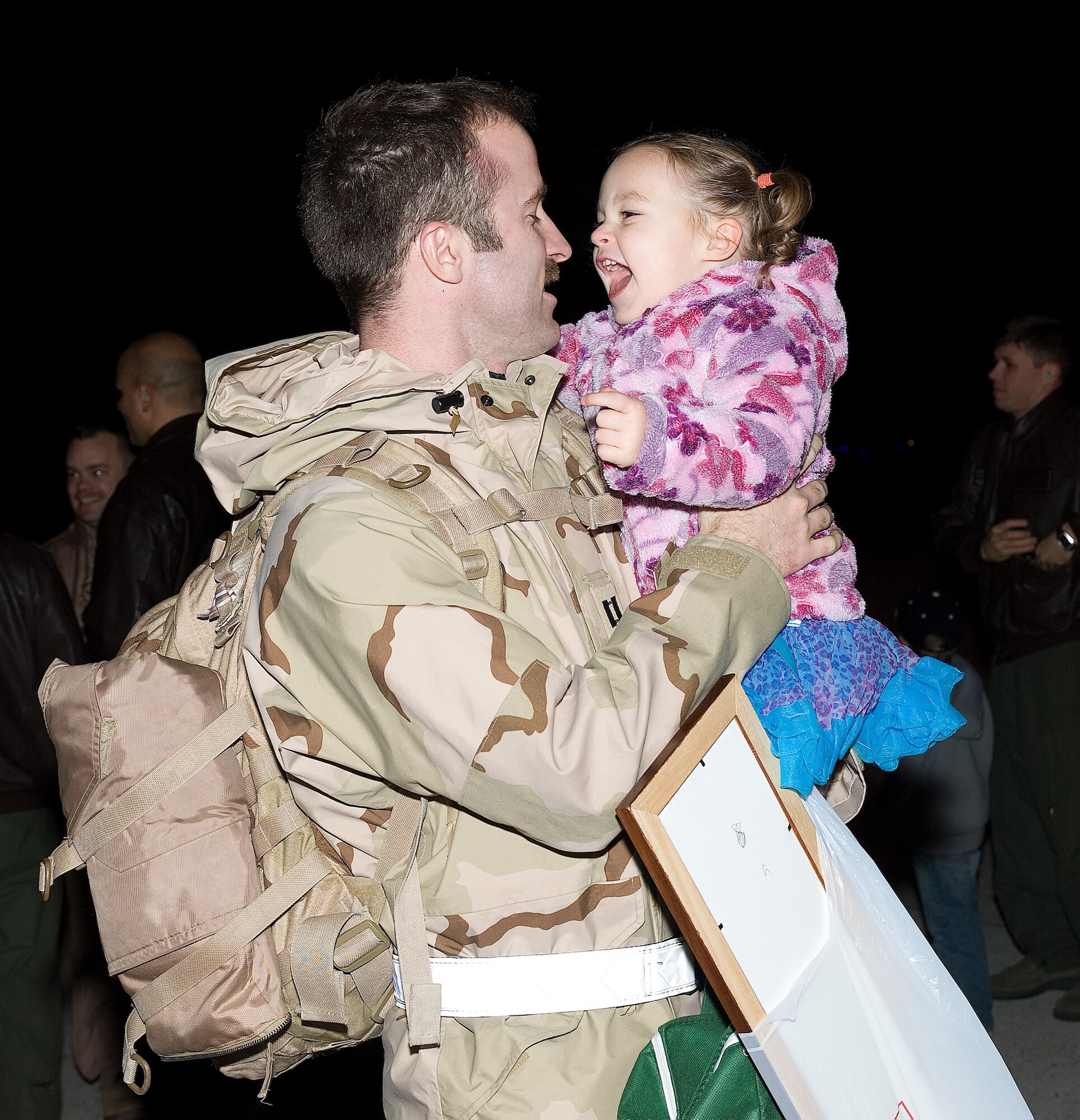 Capt. Tobin Gannett, 9th Airlift Squadron C-5 pilot, hugs his 2-year-old daughter, Ella, upon his return March 4, 2011 to Dover Air Force Base, Del. (U.S. Air Force photo by Jason Minto) 